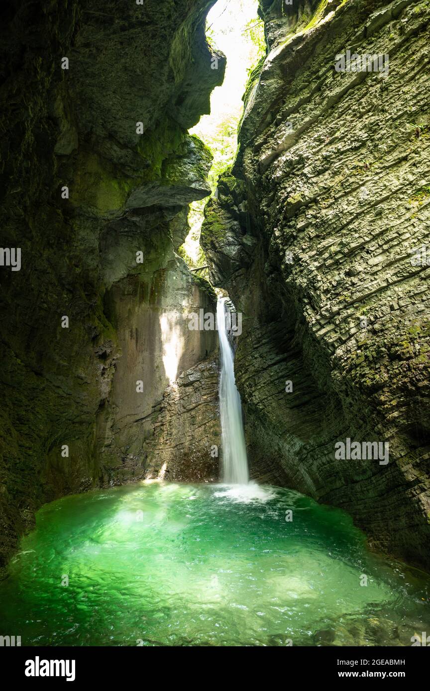 Cascade cristalline dans une grotte calcaire inondée de lumière du soleil et d'eau bleue Banque D'Images