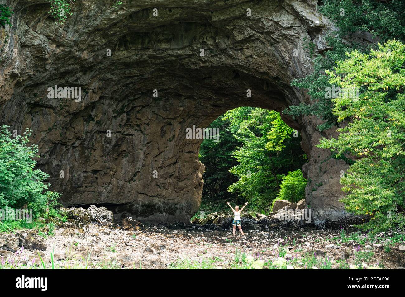 Femme blonde debout sous le pont d'arche en pierre naturelle dans le parc paysagiste de Rakov Škocjan Banque D'Images