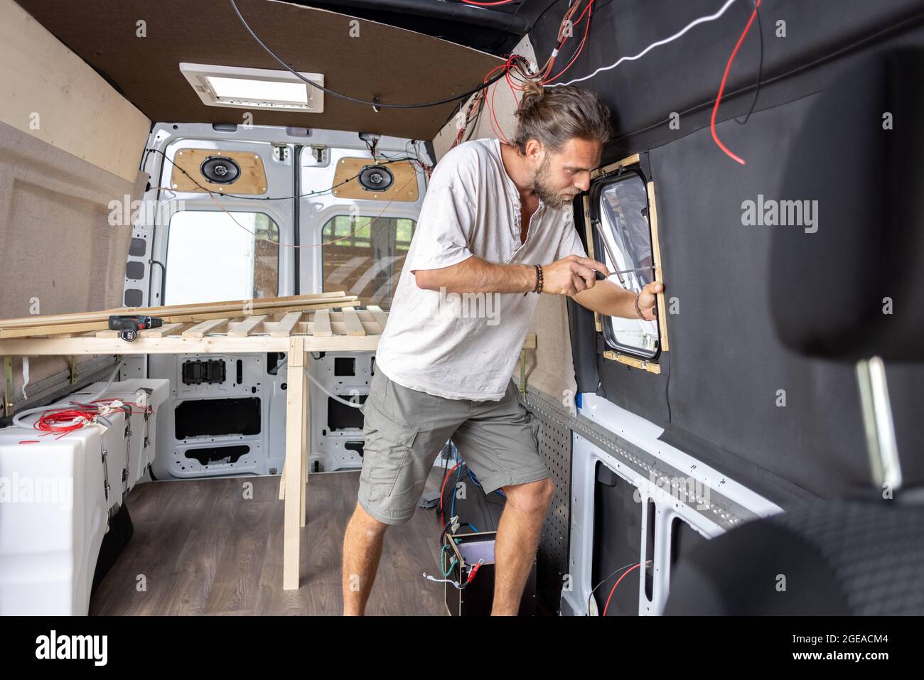 Homme travaillant à l'intérieur de sa camionnette de camping Banque D'Images