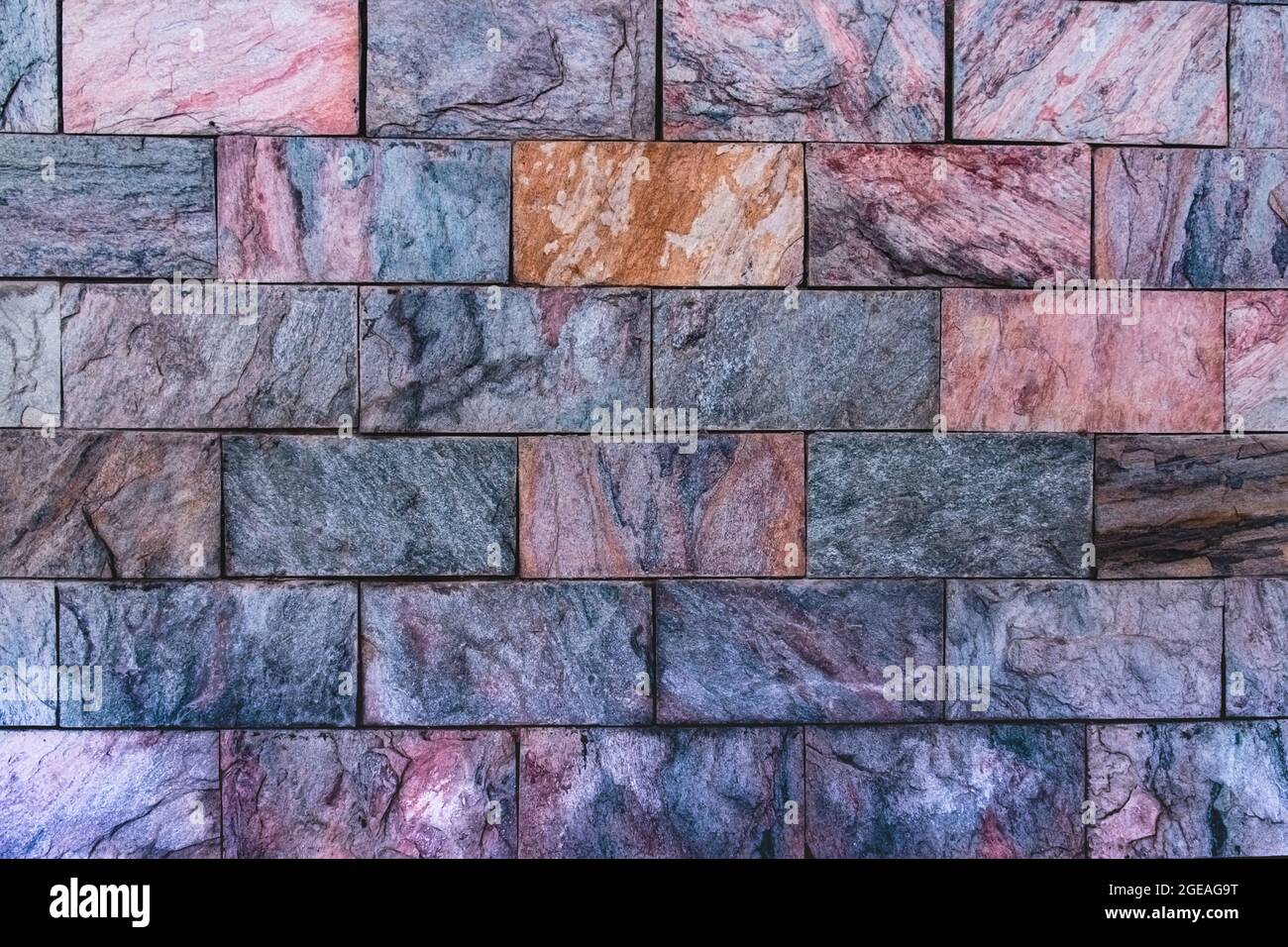 Revêtement mural décoratif avec carreaux de granit multicolores. Arrière-plan de pierres naturelles colorées. Revêtement décoratif avec ston naturel multicolore Banque D'Images