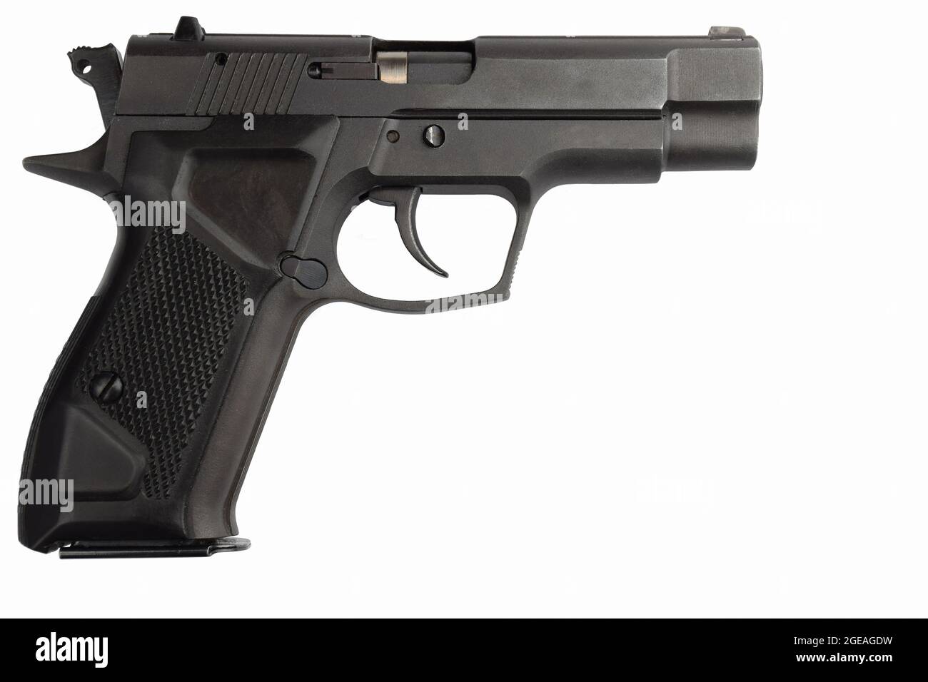 Un petit moulin décoratif en bois brun se dresse dans le jardin contre le fond d'arbres sur un piédestal en pierre Banque D'Images