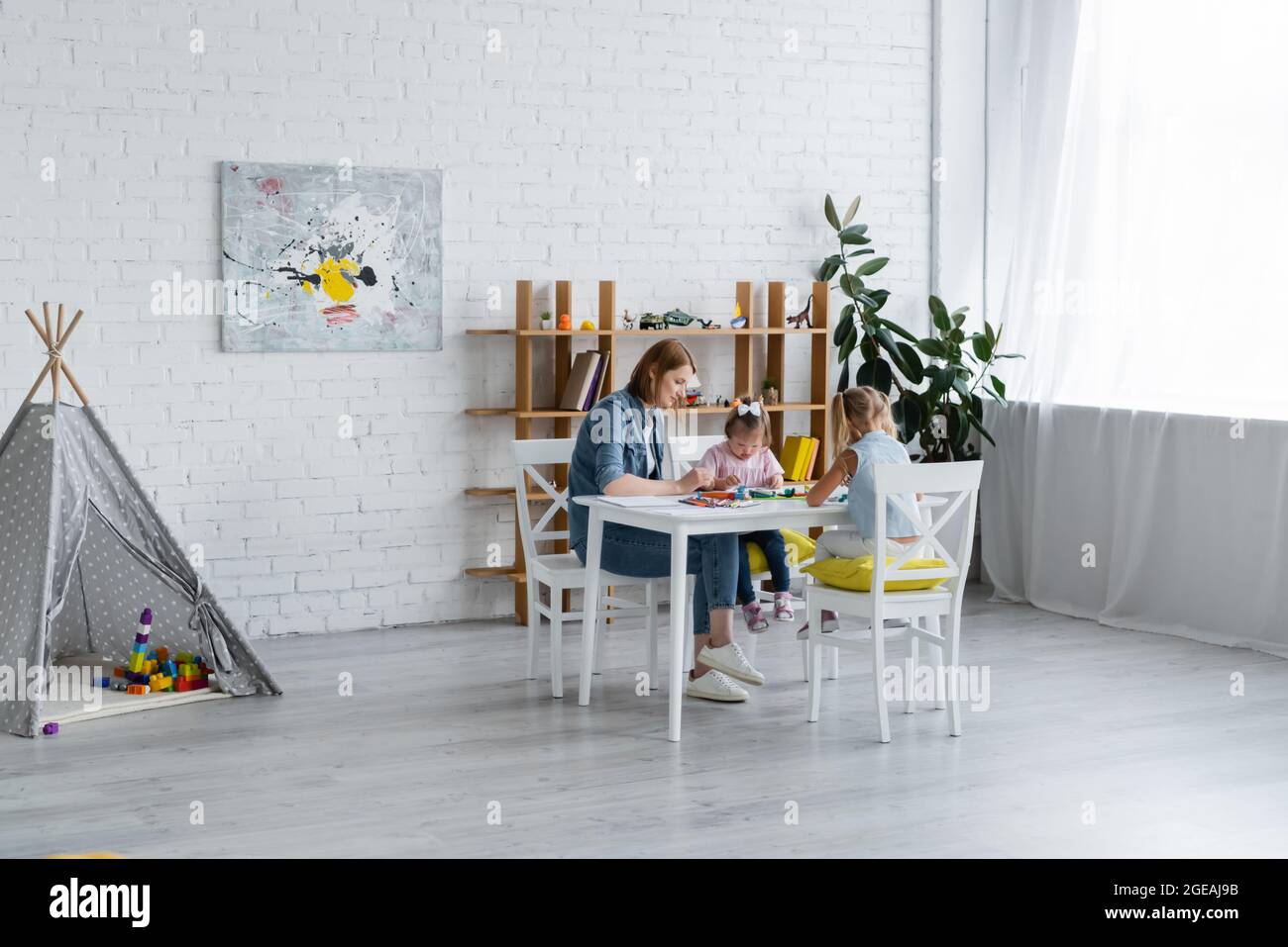 professeur de moulage de la plasticine avec les enfants dans la maternelle privée Banque D'Images