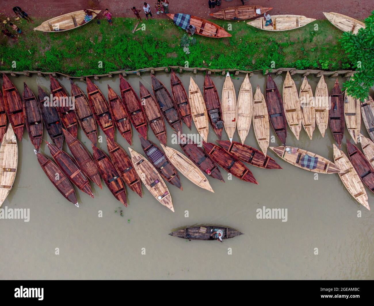 Vue aérienne des constructeurs de bateaux fabriquent des bateaux en bois à "Noukar Haat" (marché de bateaux) à Kuriana sous le Swarupkathi upazila du district de Pirojpur. Le marché de Noukar Haat, d'une longueur de deux kilomètres, est réputé pour le commerce de différentes variétés de bateaux pendant la saison de la mousson. Le marché se déroule tous les vendredis de mai à novembre. “Panis” ou “Pinis”, “Dingi” et “Naak Golui” sont les types de bateaux disponibles à la vente, construits par des artisans locaux des Muktahar, Chami, Boldia, Inderhaat, Boitha Kata, Villages de Dubi et Kathali. Le 18 août 2021 à Barishal, au Bangladesh. Photo de M Banque D'Images