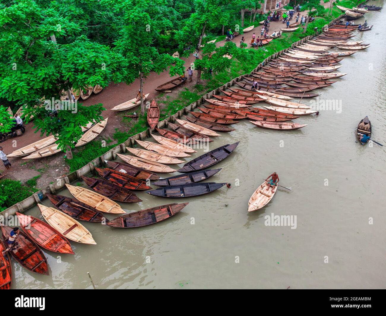 Vue aérienne des constructeurs de bateaux fabriquent des bateaux en bois à "Noukar Haat" (marché de bateaux) à Kuriana sous le Swarupkathi upazila du district de Pirojpur. Le marché de Noukar Haat, d'une longueur de deux kilomètres, est réputé pour le commerce de différentes variétés de bateaux pendant la saison de la mousson. Le marché se déroule tous les vendredis de mai à novembre. “Panis” ou “Pinis”, “Dingi” et “Naak Golui” sont les types de bateaux disponibles à la vente, construits par des artisans locaux des Muktahar, Chami, Boldia, Inderhaat, Boitha Kata, Villages de Dubi et Kathali. Le 18 août 2021 à Barishal, au Bangladesh. Photo de M Banque D'Images