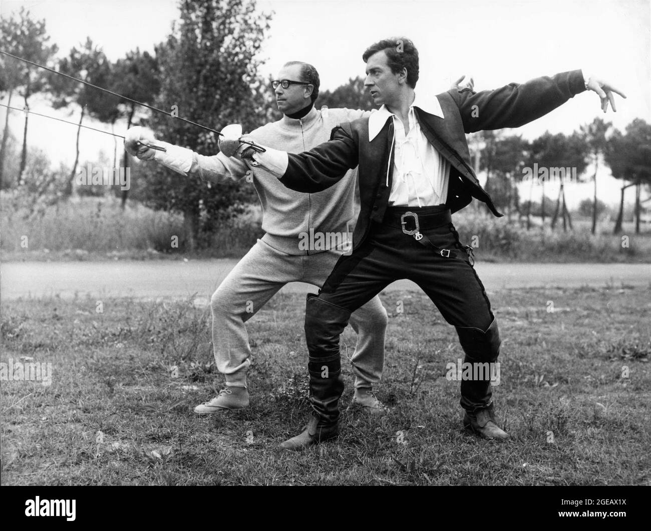 JEAN-PIERRE CASSELL en costume comme d'Artagnan sur un ensemble d'entraînement candial épée coups de combat avec Maître des armes / Maître épée ENZO MUSUMECI GRECO pendant le tournage de CYRANO et d'ARTAGNAN 1964 réalisateur / Histoire ABEL GANCE costume design Dario Cecchi France - Italie - Espagne co-production Circe production / G.E.S.I. Cinématografica / Compagnia Cinématografica Champion / Agata films S.A. / Costantini film Banque D'Images