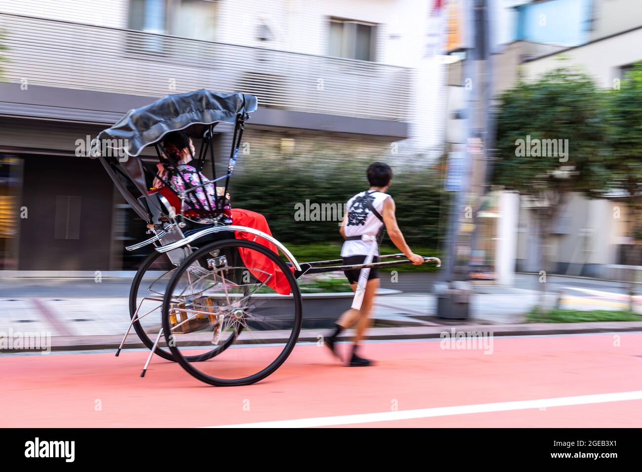 Un pousse-pousse ou un jinrikisha transporte les touristes autour du temple bouddhiste Sensoji et du quartier historique d'Asakusa à Tokyo, au Japon. Banque D'Images