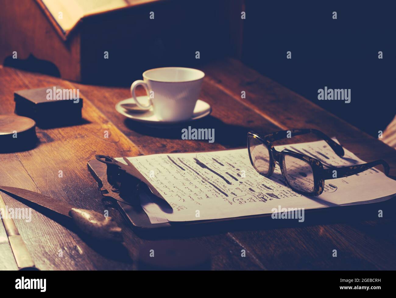 Détail d'UN écrivain ou d'un bureau académique avec un manuscrit, des lunettes et UNE tasse de thé Banque D'Images