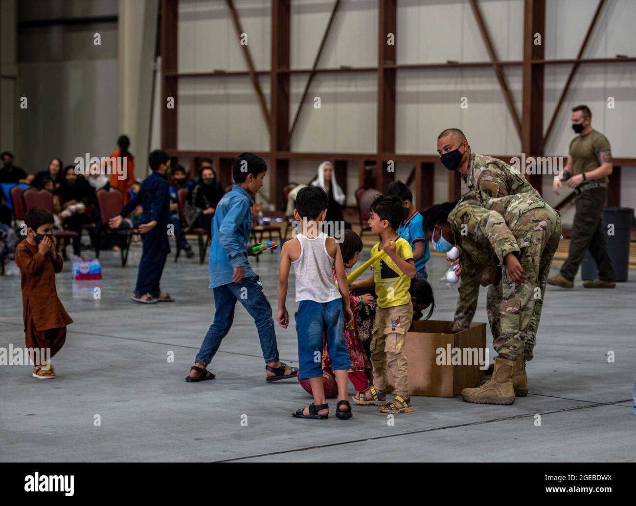 Les membres de la 379e Escadre expéditionnaire aérienne distribuent des jouets aux citoyens afghans dans le cadre de l'opération alliés refuge, le 16 août 2021, à la base aérienne d'Al Udeid, au Qatar. Le ministère de la Défense s'est engagé à appuyer le département d'État des États-Unis dans le départ du personnel civil américain et allié de l'Afghanistan, et à évacuer les alliés afghans en toute sécurité. (É.-U. Photo de la Force aérienne par Airman 1ère classe Kylie Barrow) Banque D'Images