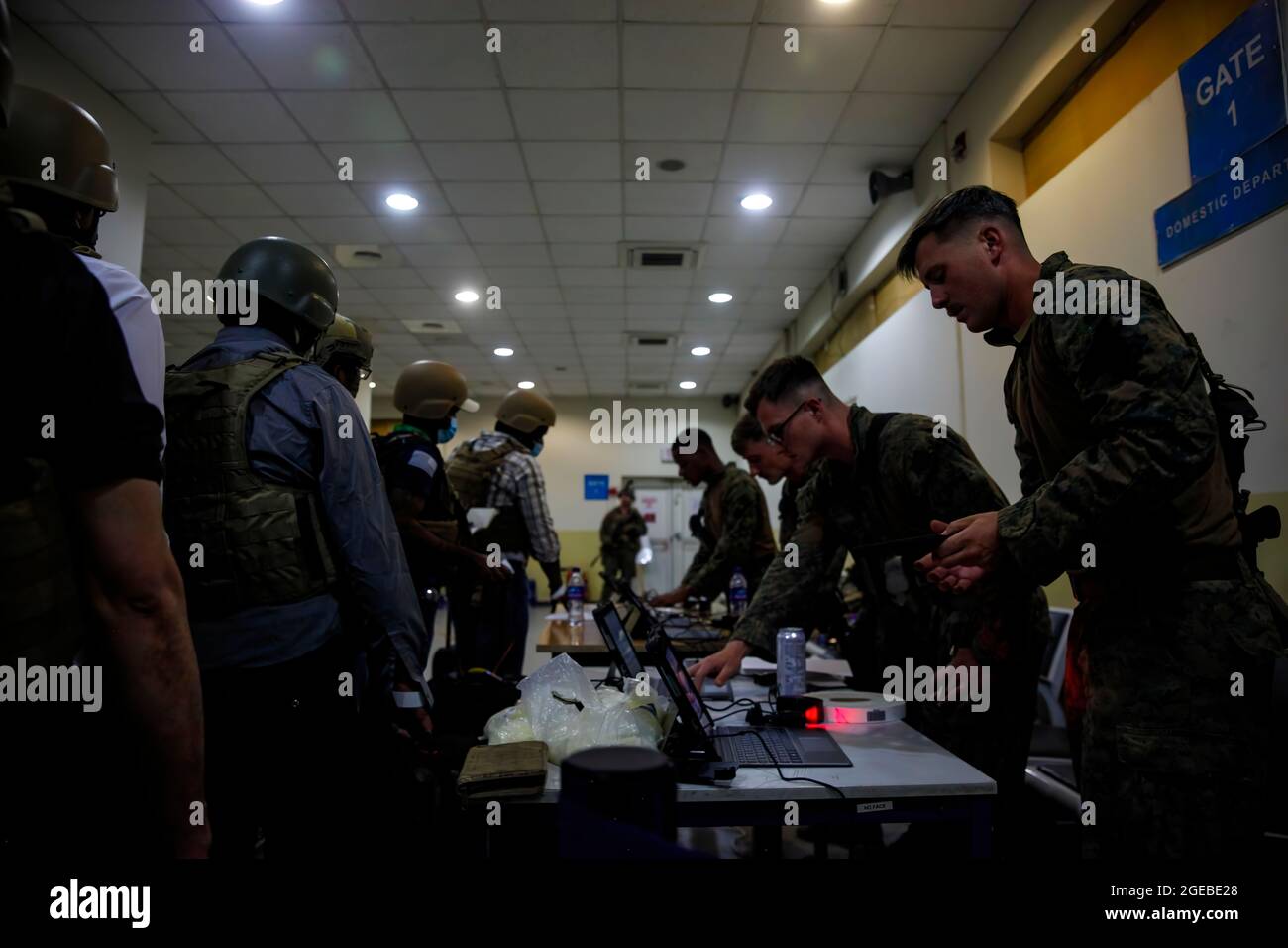 Marines de la 24e unité expéditionnaire maritime (UMM) processus personnel du Département d'État pour l'évacuation à l'aéroport international Hamid Karzaï, Kaboul, Afghanistan, août 15. Les soldats américains et les Marines aident le Département d'État à faire un retrait ordonné du personnel désigné en Afghanistan. (É.-U. Photo du corps marin par Sgt. Isaiah Campbell) Banque D'Images