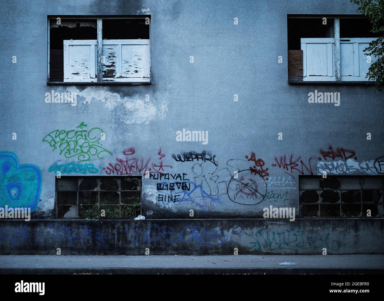 Graffiti sur un bâtiment avec de nombreuses fenêtres écrasées à Zagreb, Croatie Banque D'Images