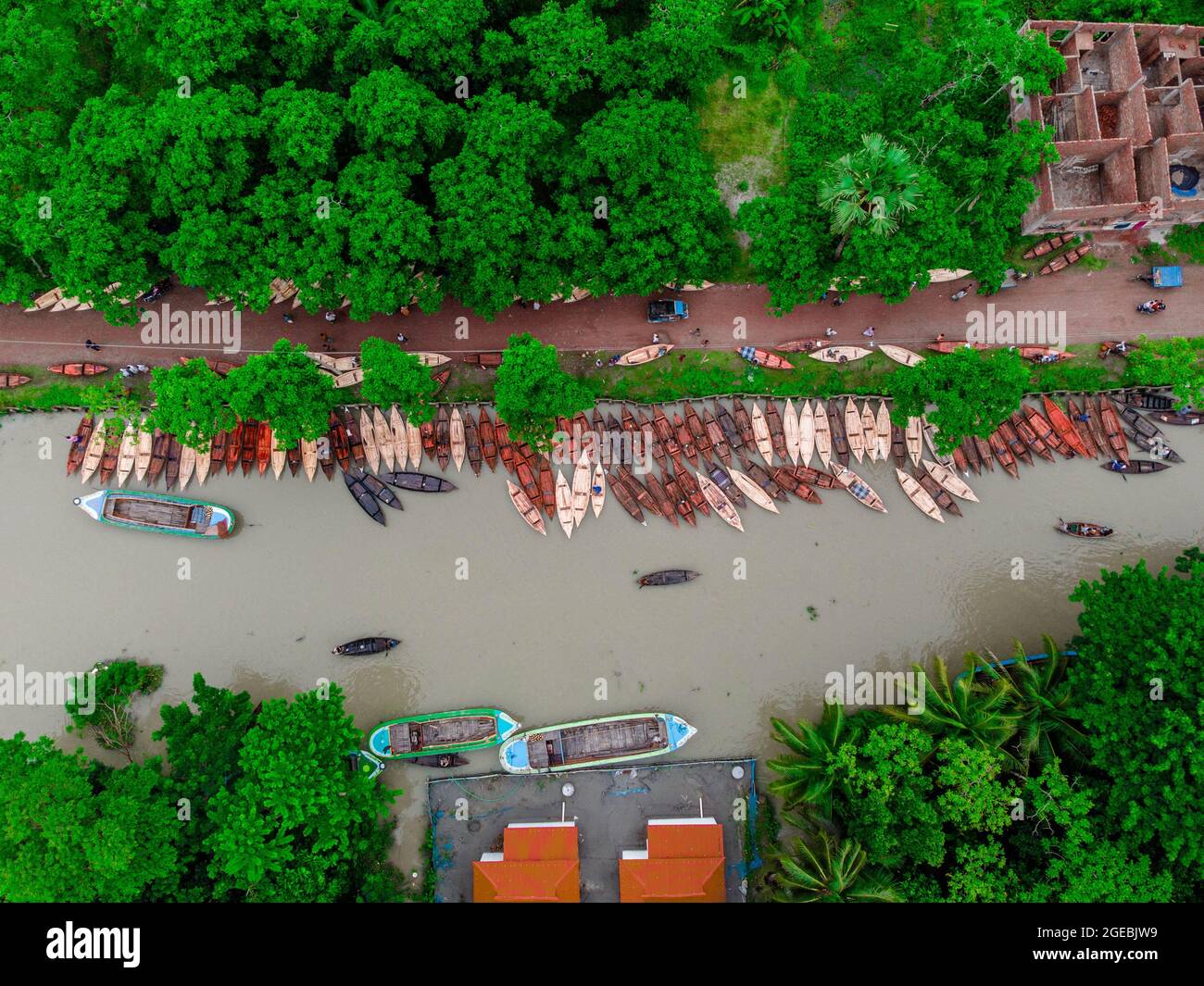 Barishal (Bangladesh), le 18 août 2021 : vue aérienne des constructeurs de bateaux fabriquent des bateaux en bois à «Noukar Haat» (marché de bateaux) à Kuriana, sous la section Swarupkathi upazila de Pirojpur. Le marché de Noukar Haat, d'une longueur de deux kilomètres, est réputé pour le commerce de différentes variétés de bateaux pendant la saison de la mousson. Le marché se déroule tous les vendredis de mai à novembre. “Panis” ou “Pinis”, “Dingi” et “Naak Golui” sont les types de bateaux disponibles à la vente, construits par des artisans locaux des Muktahar, Chami, Boldia, Inderhaat, Boitha Kata, Villages de Dubi et Kathali. Crédit: M Banque D'Images