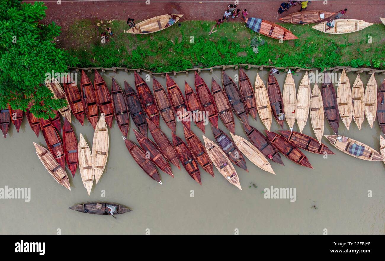 Barishal (Bangladesh), le 18 août 2021 : vue aérienne des constructeurs de bateaux fabriquent des bateaux en bois à «Noukar Haat» (marché de bateaux) à Kuriana, sous la section Swarupkathi upazila de Pirojpur. Le marché de Noukar Haat, d'une longueur de deux kilomètres, est réputé pour le commerce de différentes variétés de bateaux pendant la saison de la mousson. Le marché se déroule tous les vendredis de mai à novembre. “Panis” ou “Pinis”, “Dingi” et “Naak Golui” sont les types de bateaux disponibles à la vente, construits par des artisans locaux des Muktahar, Chami, Boldia, Inderhaat, Boitha Kata, Villages de Dubi et Kathali. Crédit: M Banque D'Images