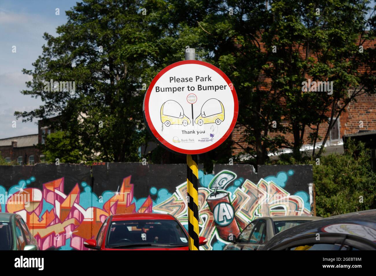 Sheffield England, parking urbain avec panneau demandant aux conducteurs de se garer de pare-chocs à pare-chocs. Banque D'Images