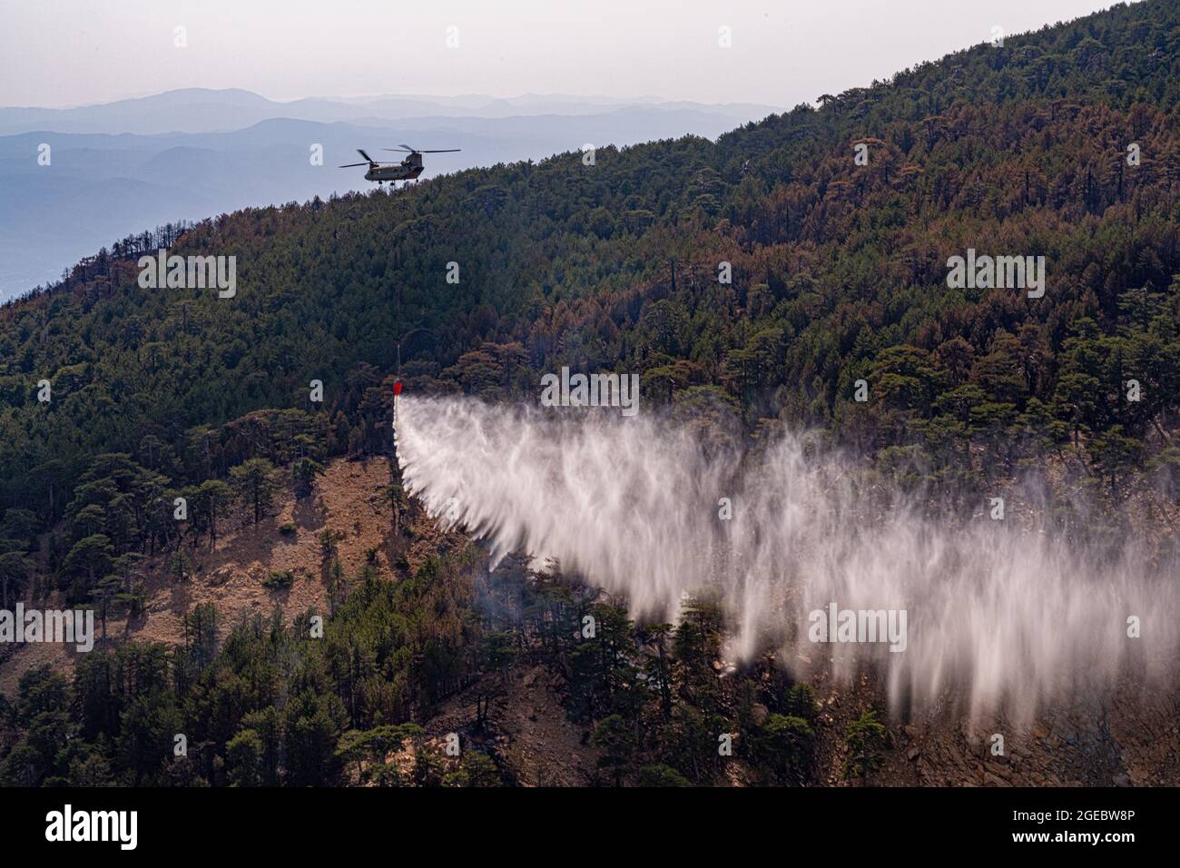 Les équipages de l'armée américaine affectés au 1er Bataillon, 214e Régiment d'aviation, 12e Brigade de l'aviation de combat, tombent de l'eau au-dessus d'un incendie dans l'ouest de la Turquie, le 14 août 2021. Les équipes remplissent les seaux d'eau des lacs voisins et des piscines artificielles plus petites spécialement créées pour soutenir les efforts de lutte contre les incendies aériens dans la région. (É.-U. Photo de l'armée par le sergent d'état-major. Christopher Stewart) Banque D'Images