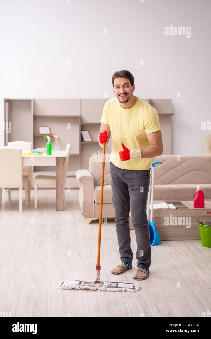 Jeune homme nettoyant la maison Banque D'Images