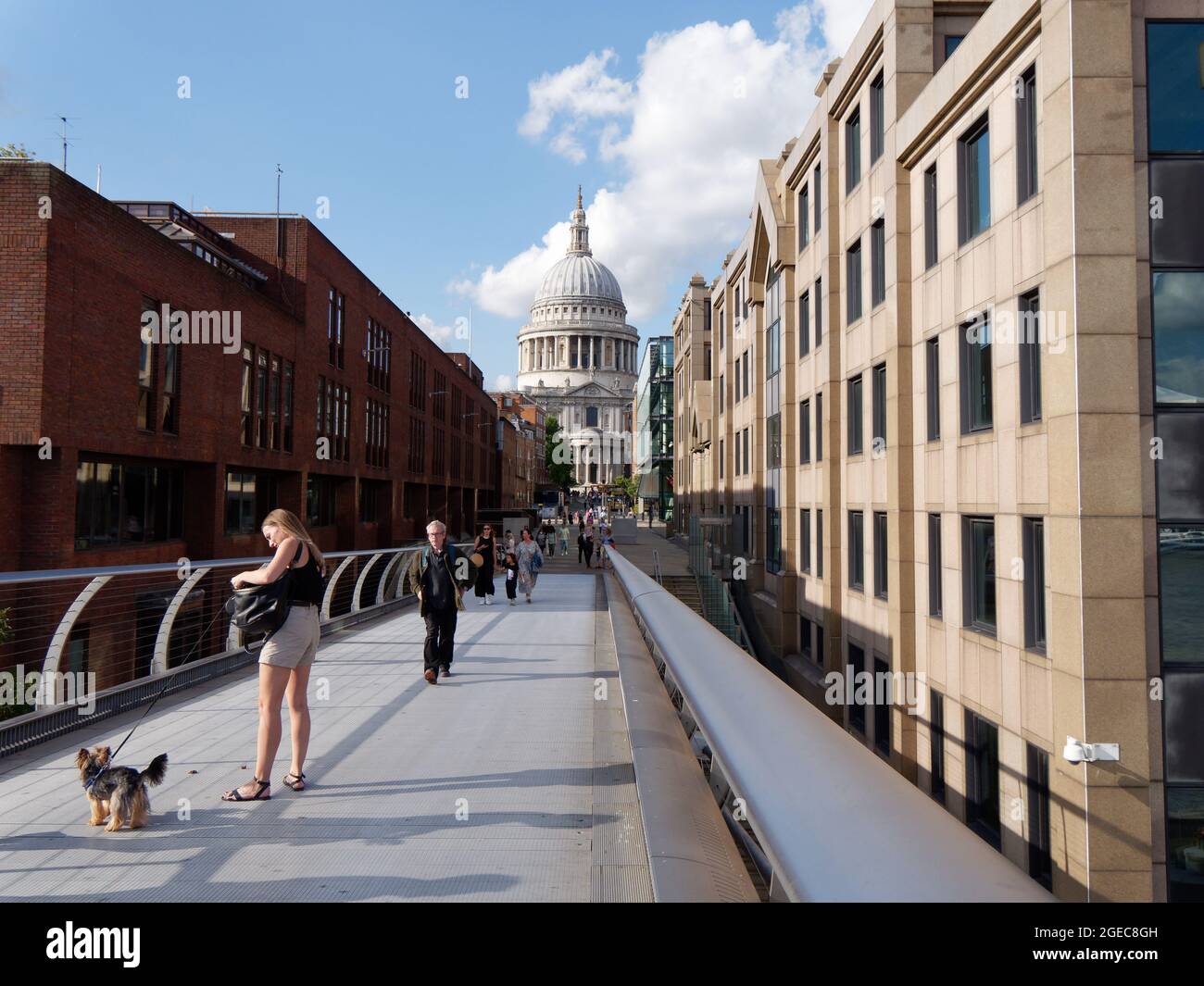 Londres, Grand Londres, Angleterre, août 10 2021 : une femme avec un chien en laisse sur le pont du Millénaire avec la cathédrale St Pauls derrière. Banque D'Images