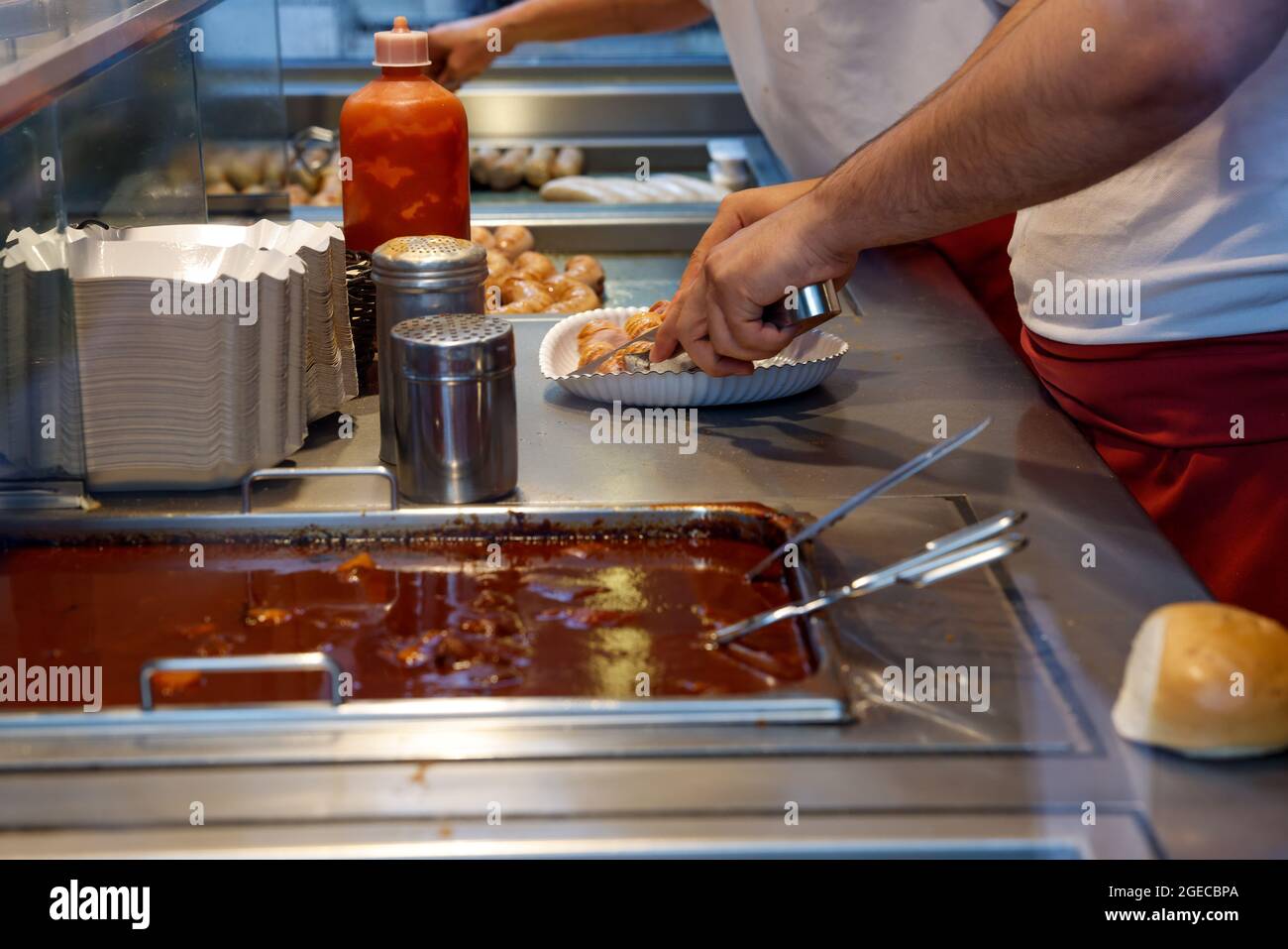 Berlin, Allemagne. 18 août 2021. Une saucisse de curry est en cours de préparation au Curry 36. Crédit : Gerald Matzka/dpa/Alay Live News Banque D'Images