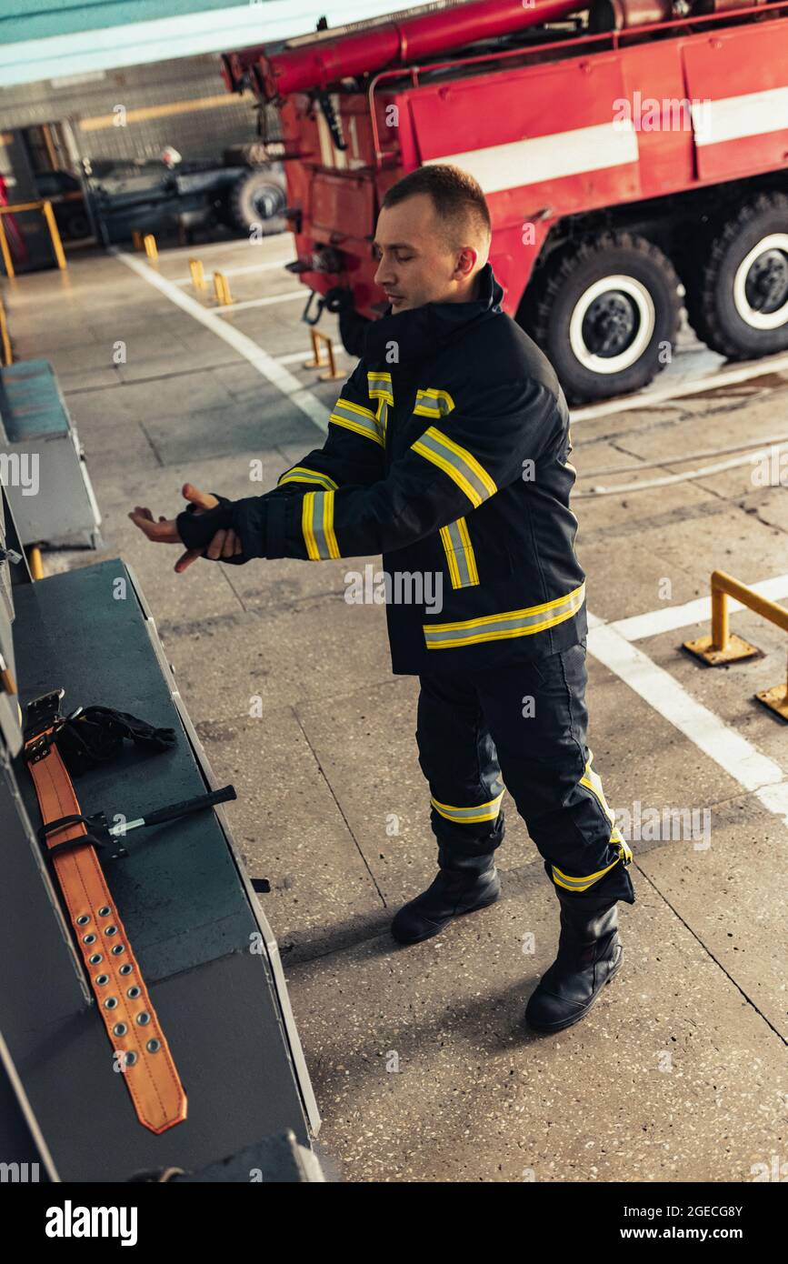 Un pompier masculin vêtu d'un uniforme avec un casque de protection à la  caserne de pompiers Photo Stock - Alamy