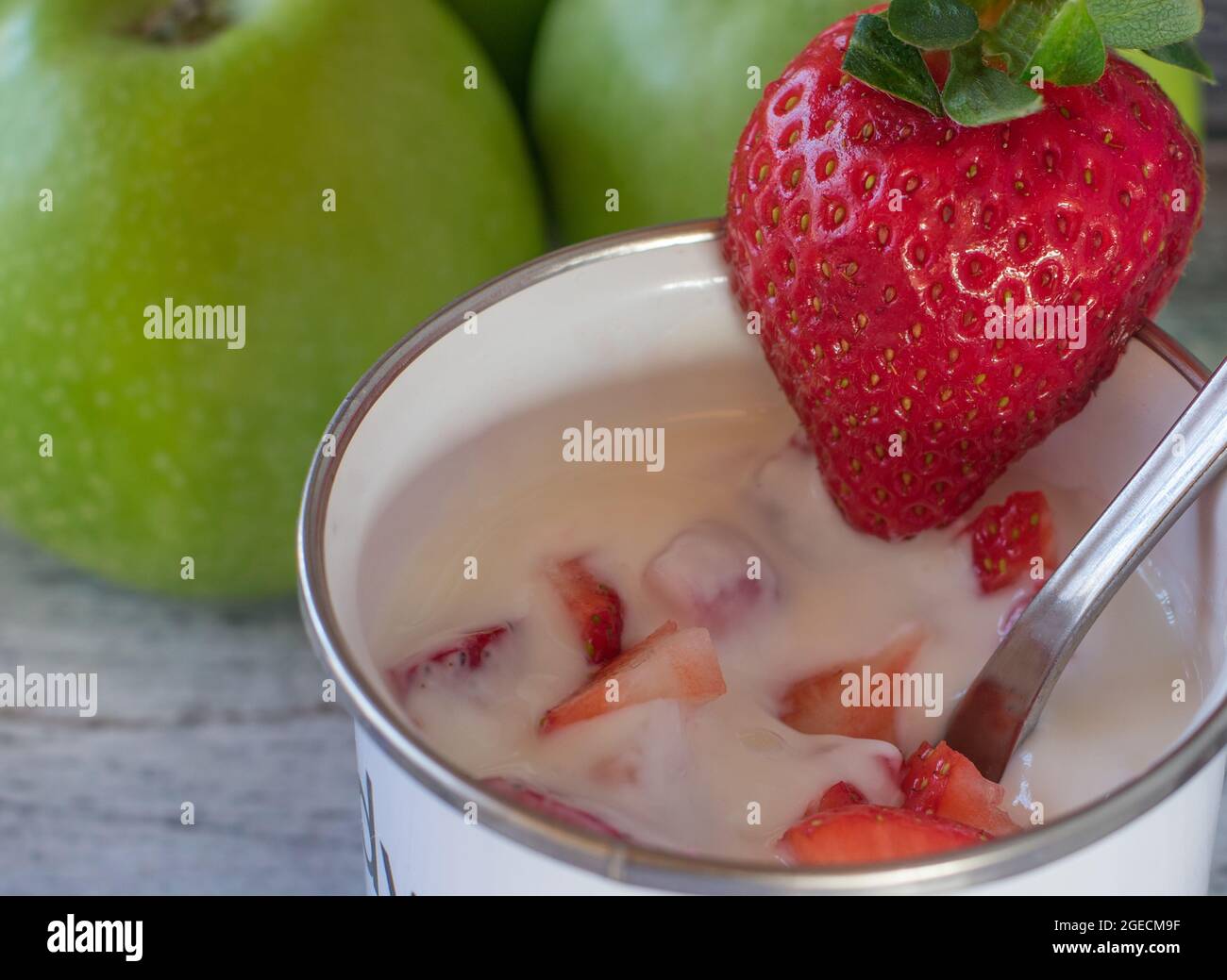 Yaourt frais avec fraises sur fond de table clair avec espace de copie. gros plan et vue isolée Banque D'Images