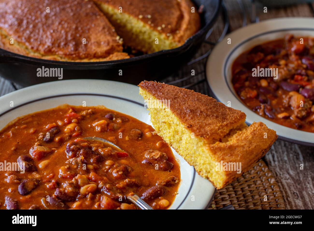 Soupe épicée aux haricots avec pain de maïs frais et fait maison sur fond rustique et en bois de table Banque D'Images