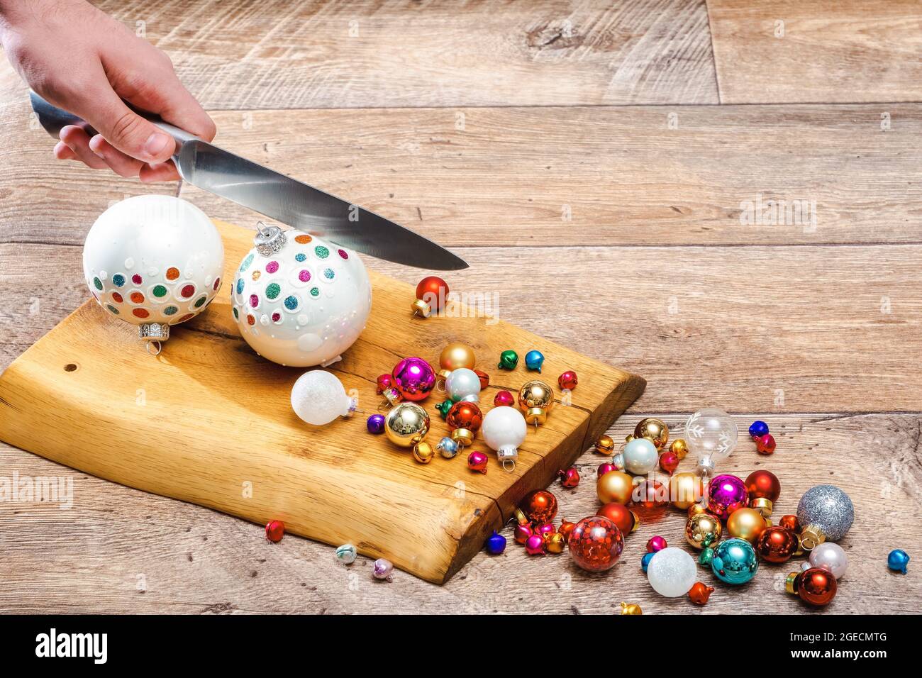 la main humaine grind des boules de noël au couteau sur une surface en bois. Cuisiner ou préparer Noël, photo conceptuelle. Photo horizontale avec espace de copie Banque D'Images