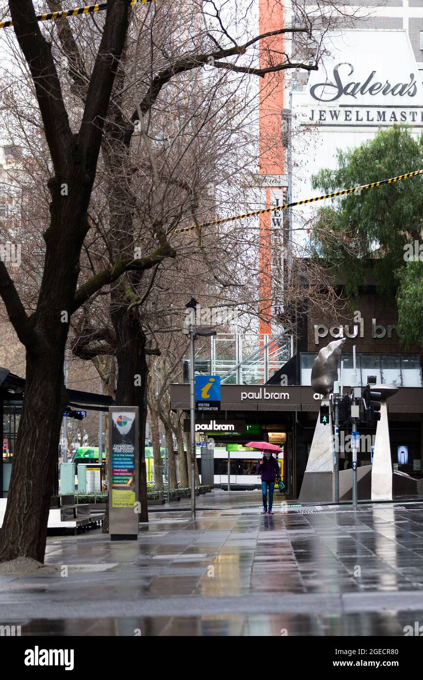 Melbourne, Australie, 14 août 2020. Une femme tenant un parapluie rouge marche le long de Swanston Street sous la pluie pendant la COVID-19 à Melbourne, en Australie. Victoria a enregistré 14 décès liés à la COVID, dont un enfant de 20 ans, marquant le plus jeune à mourir du coronavirus en Australie, et 372 nouveaux cas supplémentaires en une nuit. (Photo de Dave Hewitt/Speed Media) crédit : Dave Hewitt/Speed Media/Alamy Live News Banque D'Images