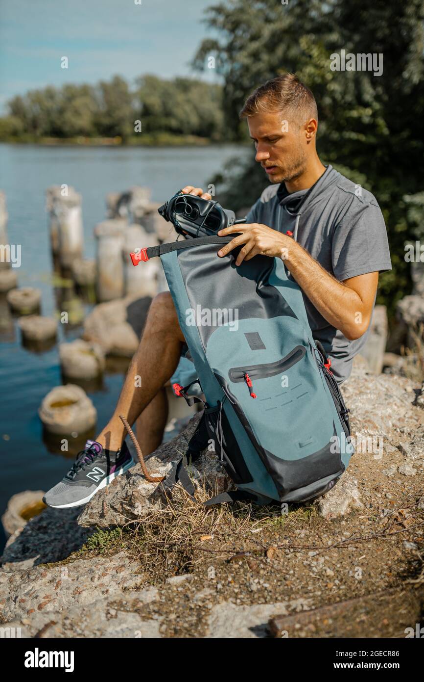 Un jeune homme empaquit son sac à dos de voyage avec un appareil photo  Photo Stock - Alamy