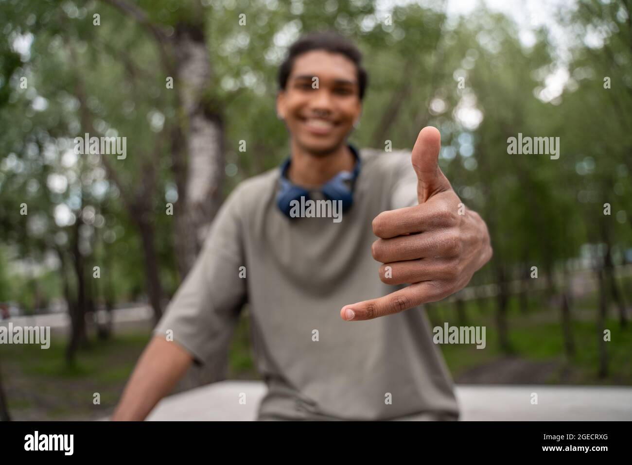 homme afro-américain flou souriant et montrant pendre le geste lâche à l'extérieur Banque D'Images