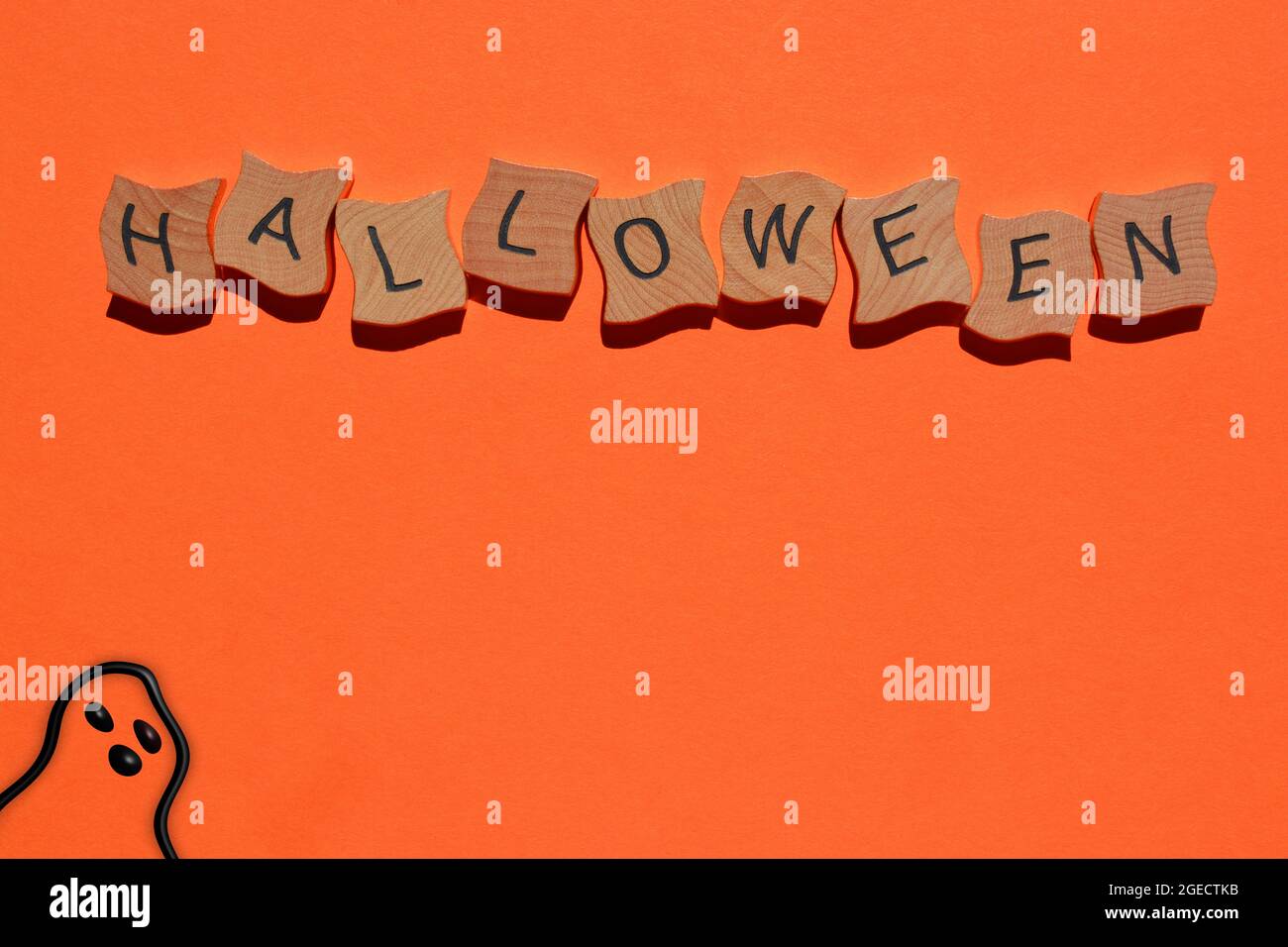 Halloween, mot en lettres de l'alphabet de bois avec fantôme dessiné à la main sur fond orange Banque D'Images