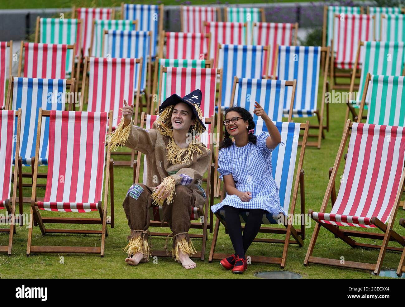 Aditi Jehangir en tant que Dorothy et Ewan Shand en tant que Scarecrow représentant le magicien d'Oz un des films populaires alignés pour le Festival du film de cette année dans la ville s'assoient sur des chaises longues dans une zone d'observation extérieure de la place St Andrew, dans le cadre du Festival international du film d'Édimbourg. Date de la photo: Jeudi 19 août 2021. Banque D'Images