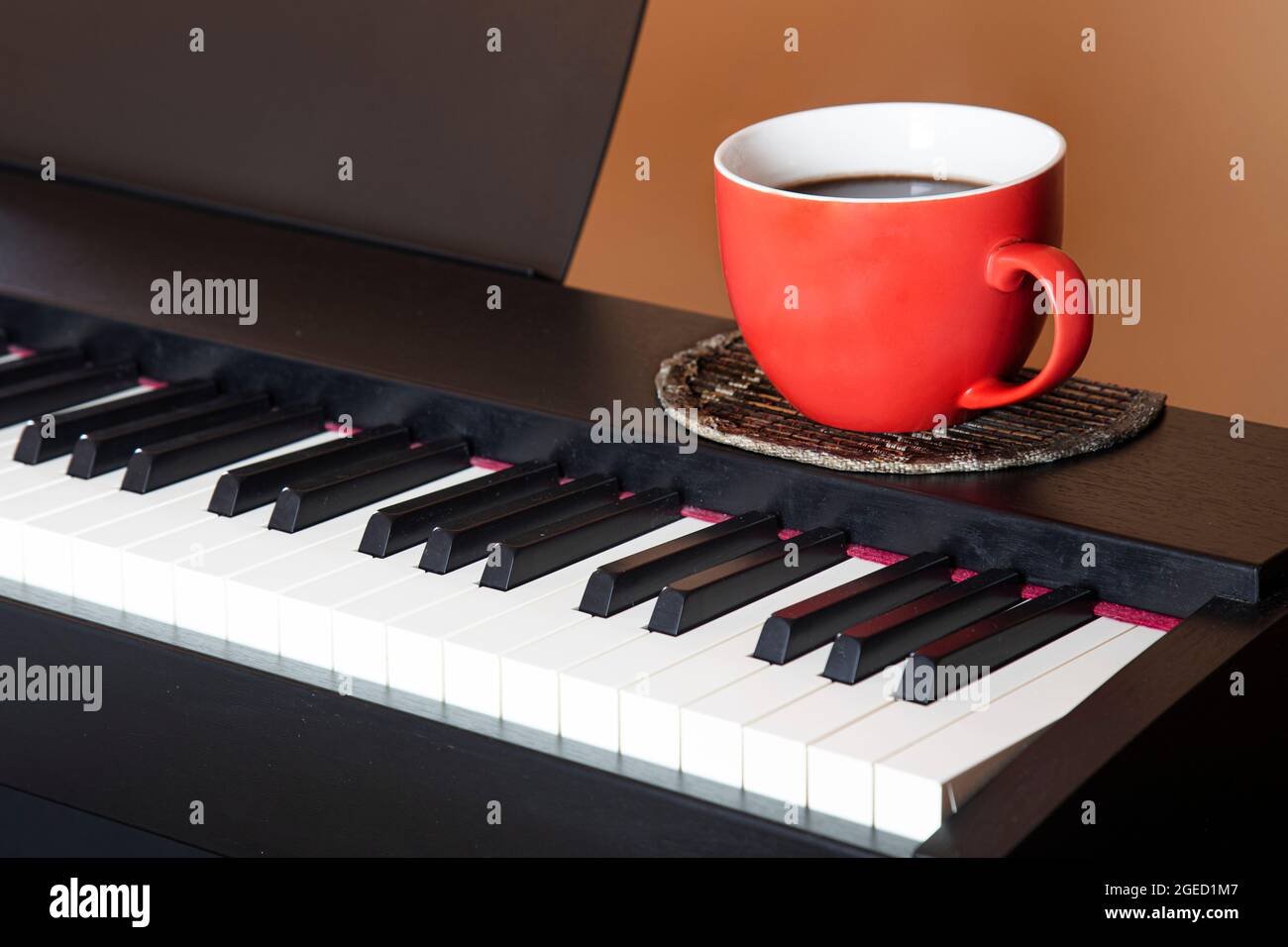 Grande tasse rouge avec café américain sur le piano Banque D'Images