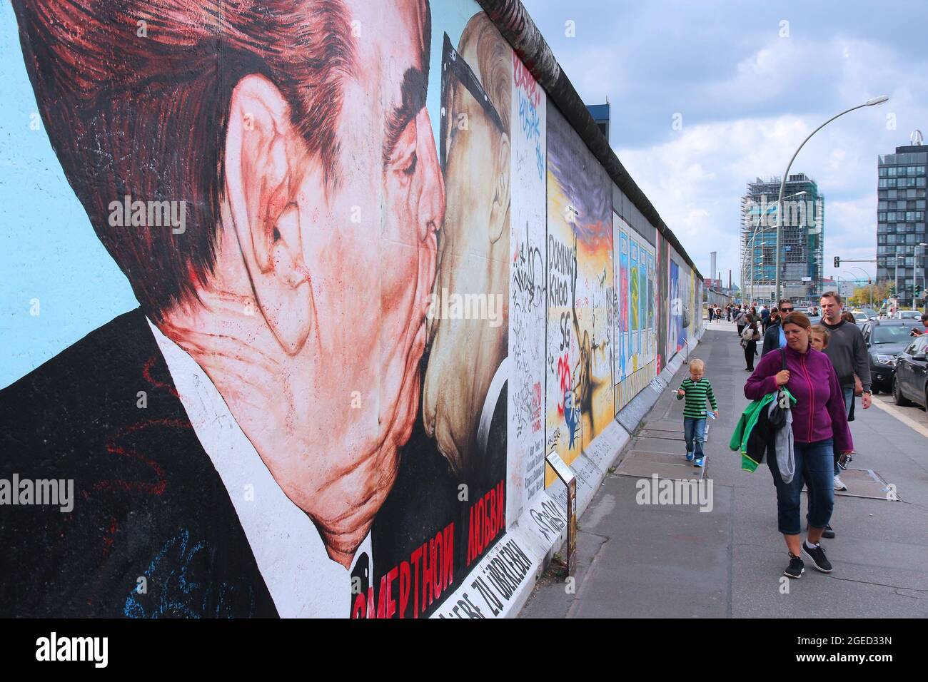 BERLIN, ALLEMAGNE - 26 AOÛT 2014 : les gens marchent sur un trottoir public le long du mur de Berlin (Berliner Mauer). La frontière emblématique du rideau de fer a divisé Berlin en Banque D'Images