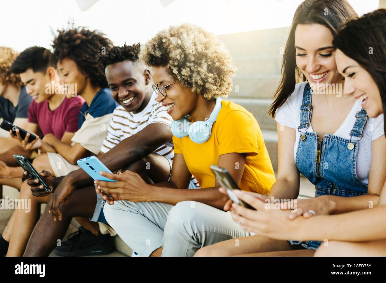 Groupe multiethnique de jeunes amis utilisant le téléphone mobile Banque D'Images