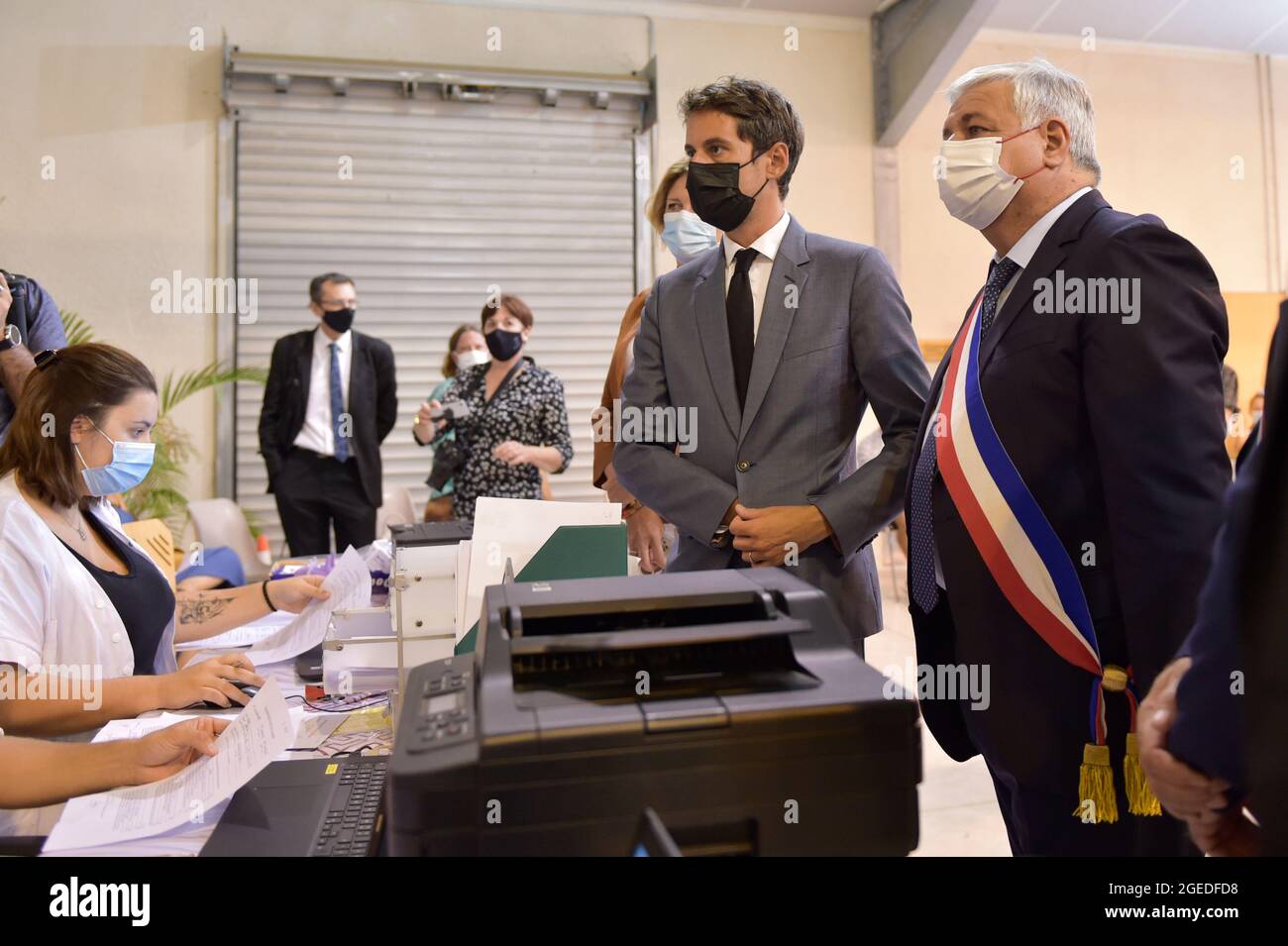 Brignoles, Var, France. 18 août 2020. Didier Bremond(R), maire de Brignoles et Gabriel Attal (L), porte-parole du gouvernement, discutent avec les équipes de soignants du centre de vaccination. Le passe sanitaire pour les magasins et les restaurants est mis en place progressivement depuis le début du mois d'août. L'objectif du gouvernement est d'avoir au moins 50 millions de personnes qui recevront leur première injection de vaccin Covid-19 d'ici la fin du mois d'août. Les fonctionnaires augmentent leurs visites dans les établissements de santé pour s'assurer que les règles sont appliquées et pour éclairer les professions touchées par la nouvelle vaccination Banque D'Images
