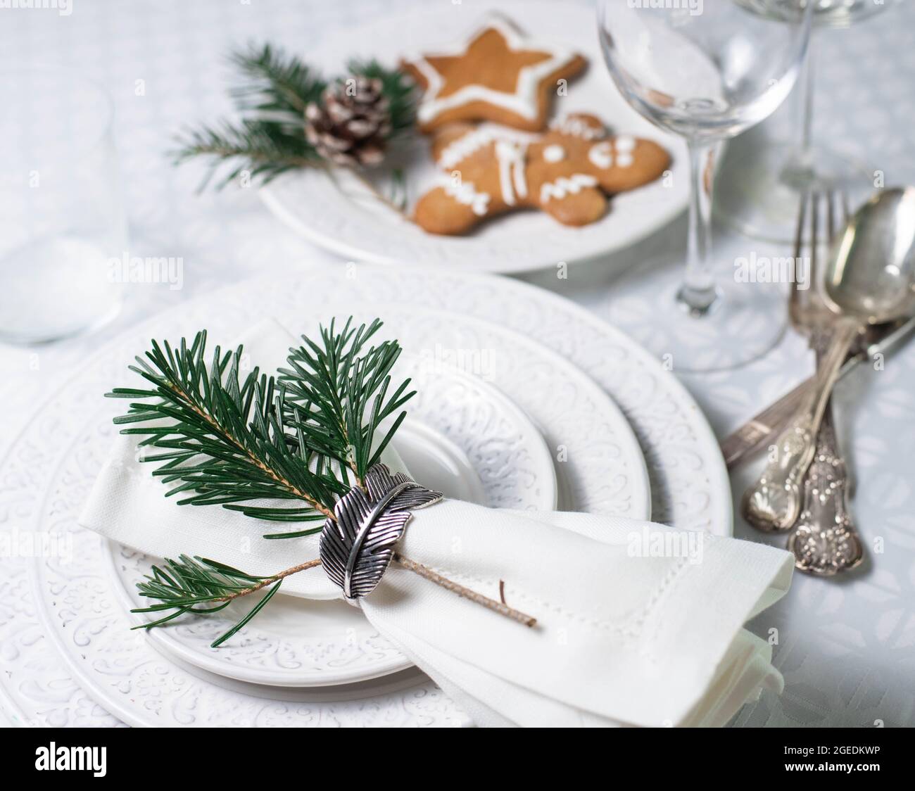 Table de Noël avec assiettes texturées blanches, couverts vintage et biscuits de noël traditionnels Banque D'Images