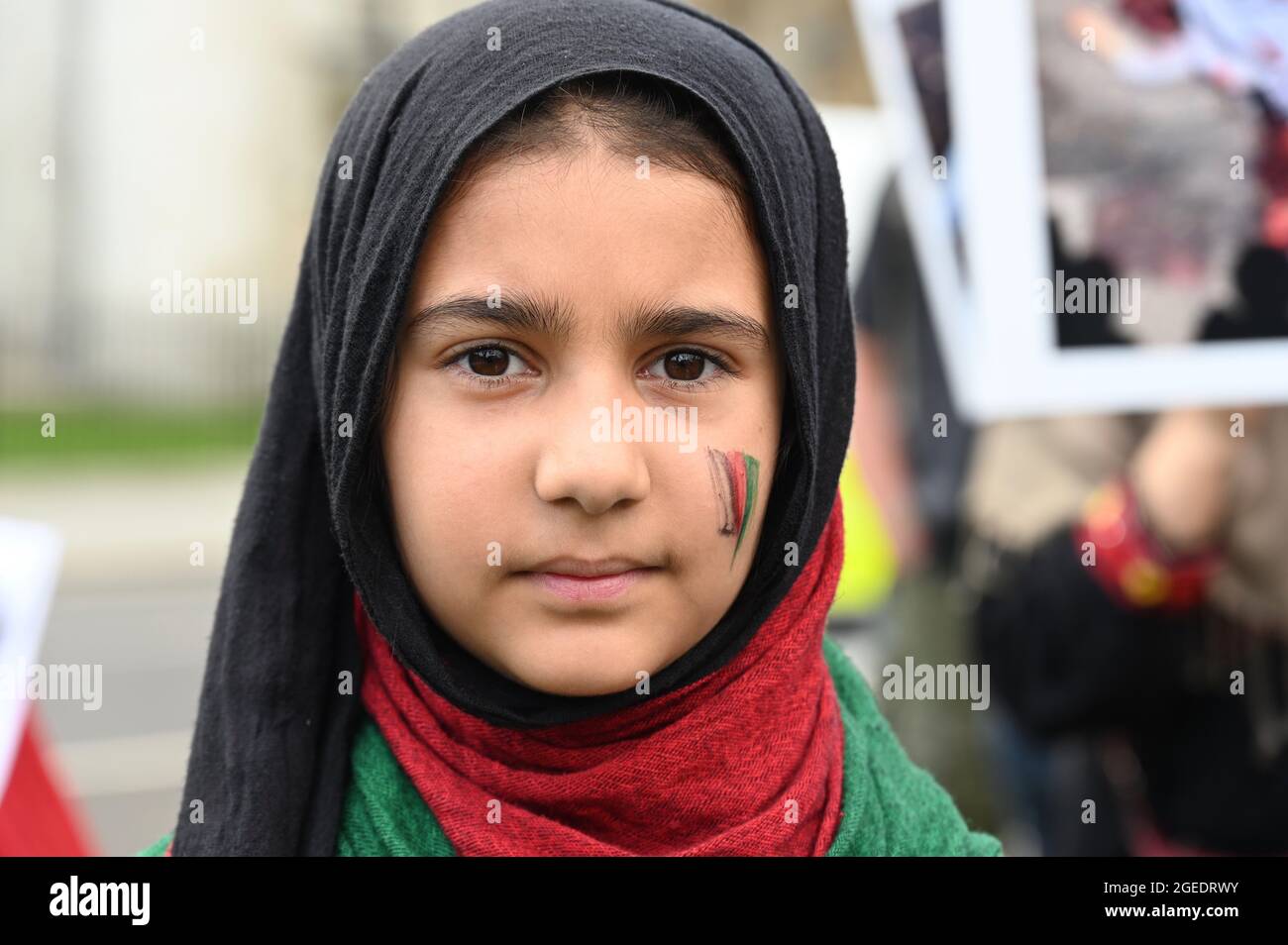 Une fille afghane au visage peint drapeau de l'Afghanistan sur sa joue, manifestation en Afghanistan, place du Parlement, Westminster, Londres. ROYAUME-UNI Banque D'Images