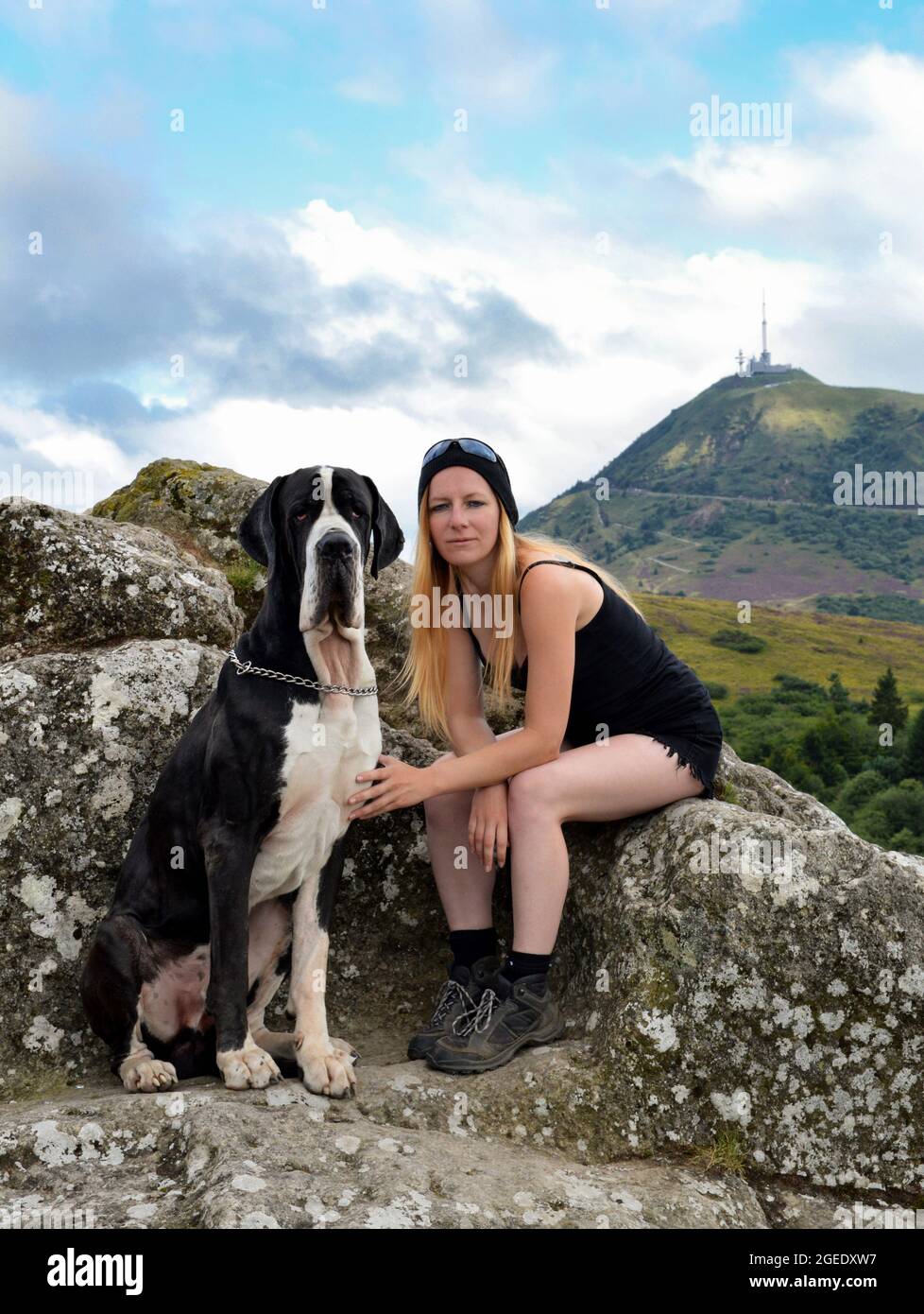 Une femme randonneur avec son chien avec une belle vue sur une montagne volcanique.Volcan Puy de Dome en Auvergne. Banque D'Images