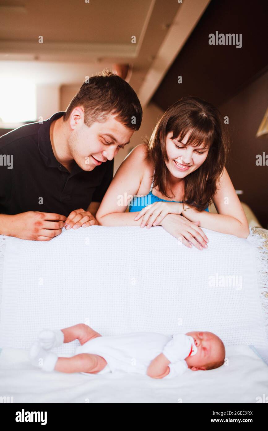 les parents regardent un nouveau-né endormi bébé Banque D'Images