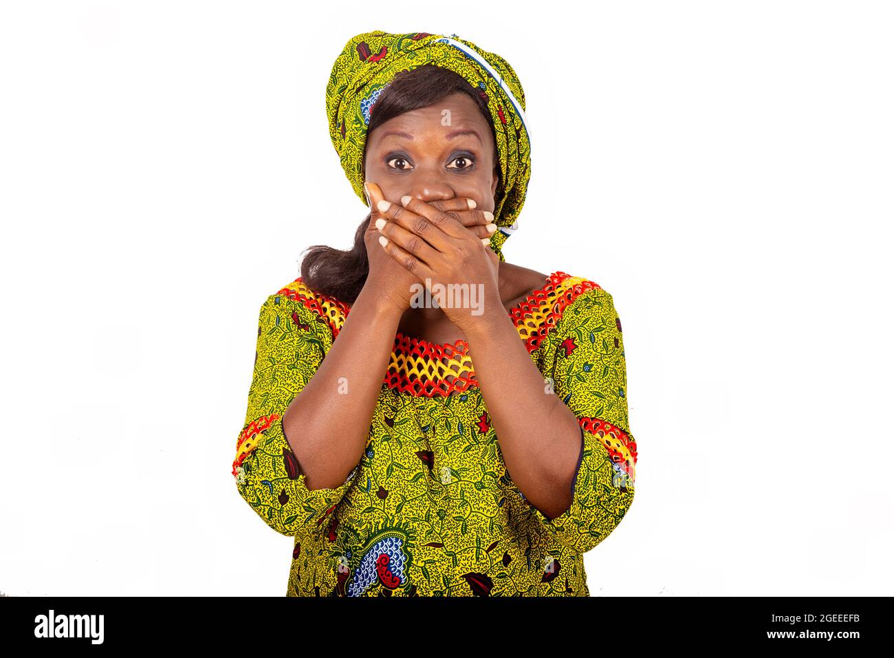 belle femme adulte africaine portant un chiffon vert qui ferme la bouche avec les deux mains Banque D'Images