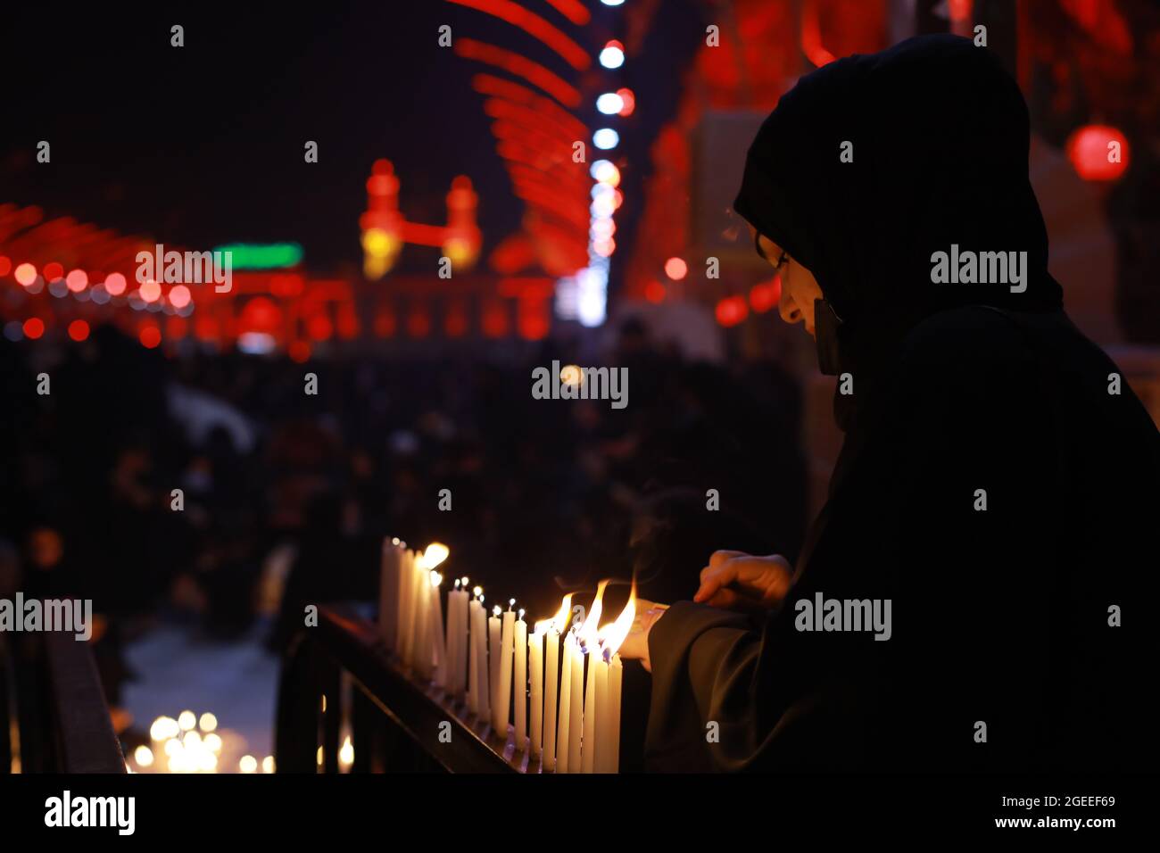 Karbala, Irak. 19 août 2021. Une femme musulmane chiite allume des bougies au sanctuaire de l'Imam Abbas dans la ville sainte irakienne de Karbala le jour de l'Ashura, le 10 de Muharram, le premier mois du calendrier islamique. Muharram est considéré comme un mois de deuil et de mémoire pour les musulmans chiites dans le monde entier, dans lequel ils commémorent le martyre du petit-fils du prophète islamique Mohammad, Husayn ibn Ali, qui a été tué lors de la bataille de Karbala au VIIe siècle. Credit: Ameer Al Mohmedaw/dpa/Alamy Live News Banque D'Images