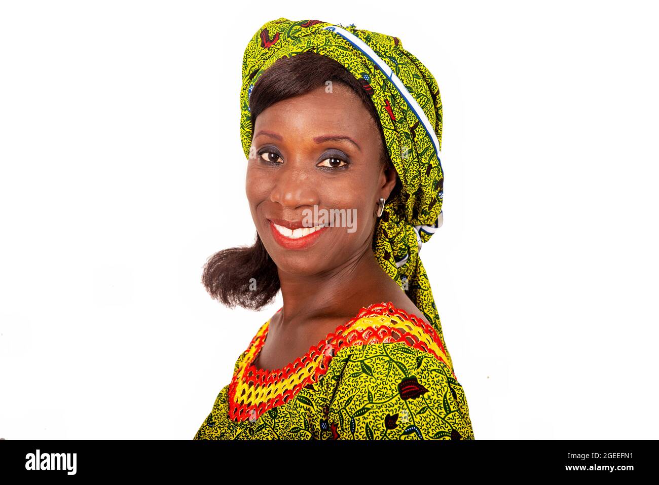 Belle femme adulte africaine vêtue de tissu vert est souriante. Banque D'Images