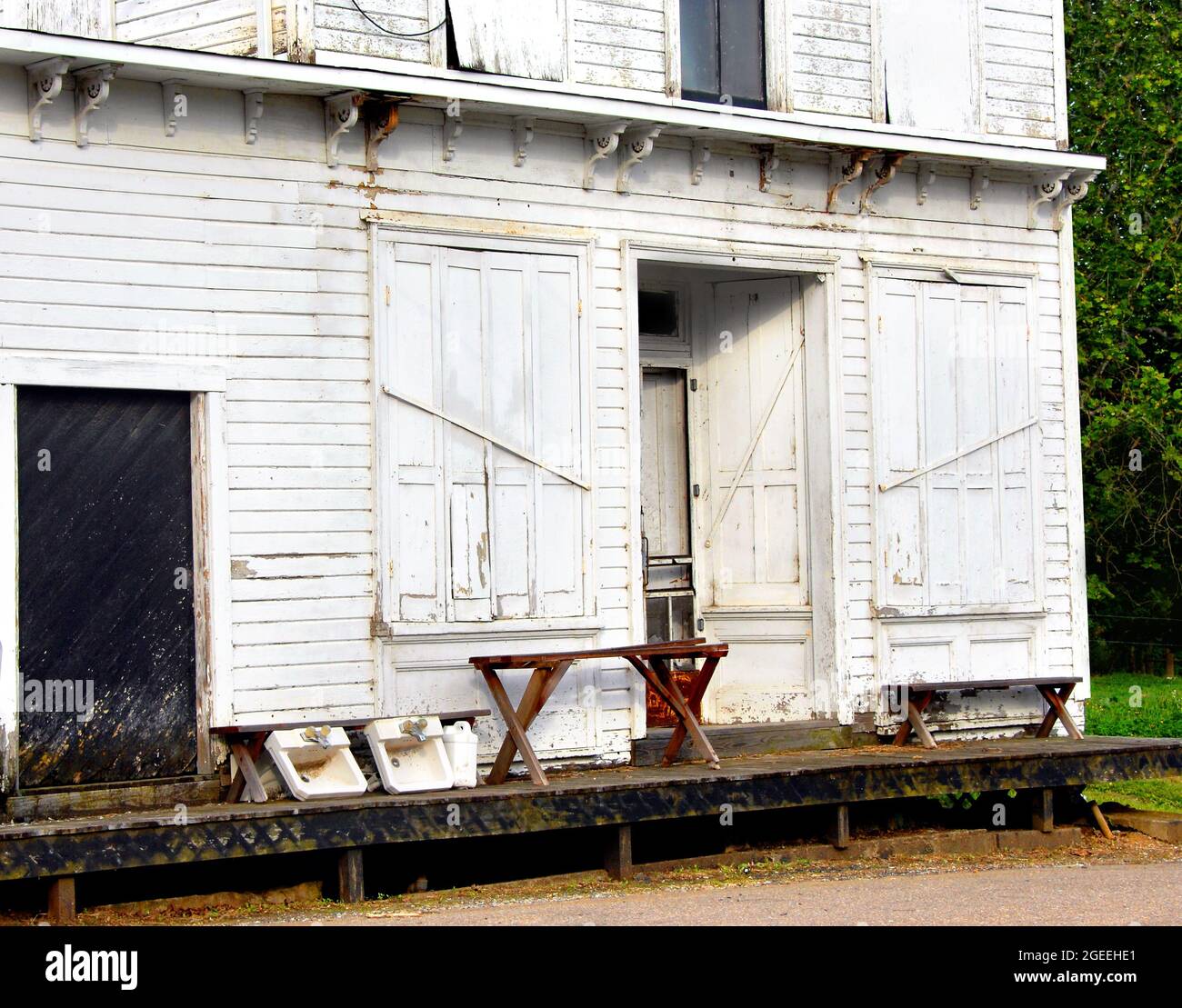 Vieux, blanc, magasin de campagne en bois dans le Tennessee a la promenade en bois de planche courant devant le bâtiment. Deux bancs en bois sont vides et le magasin est permanent Banque D'Images