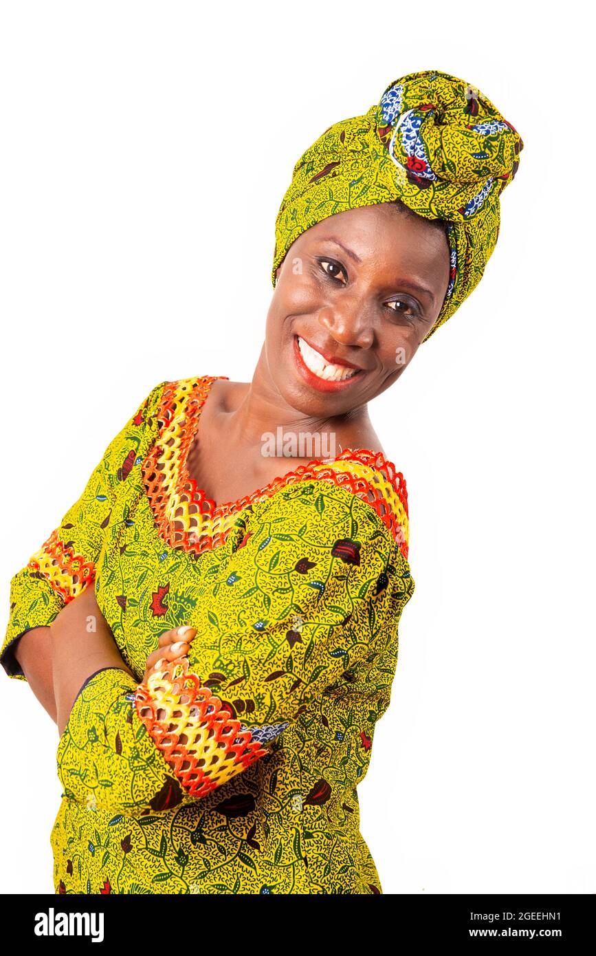 belle femme adulte africaine vêtue de tissu de longe et de foulard vert est souriant latéralement croisant les bras Banque D'Images