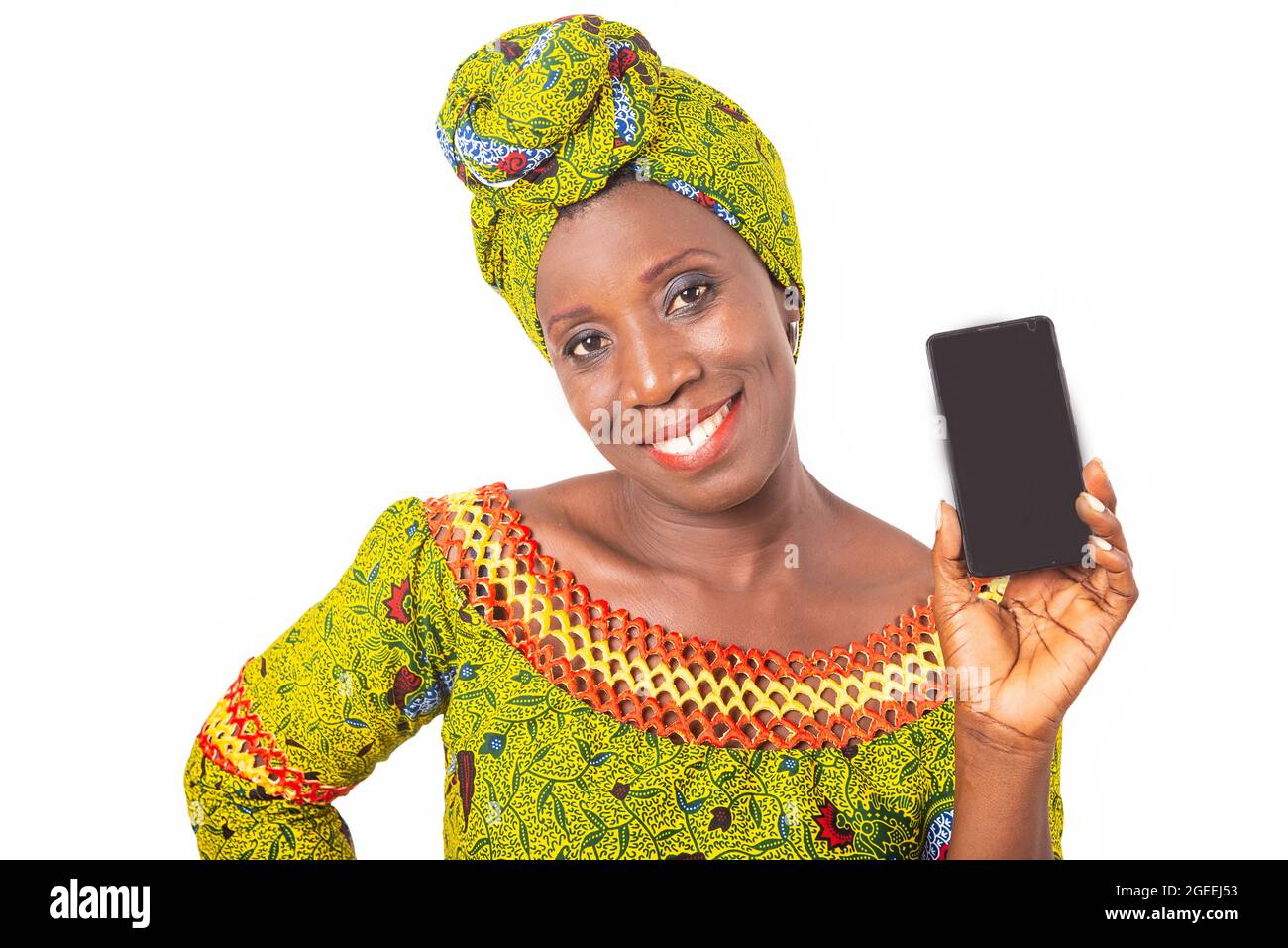 belle femme adulte africaine vêtue de tissu vert est souriant montrant un téléphone portable Banque D'Images