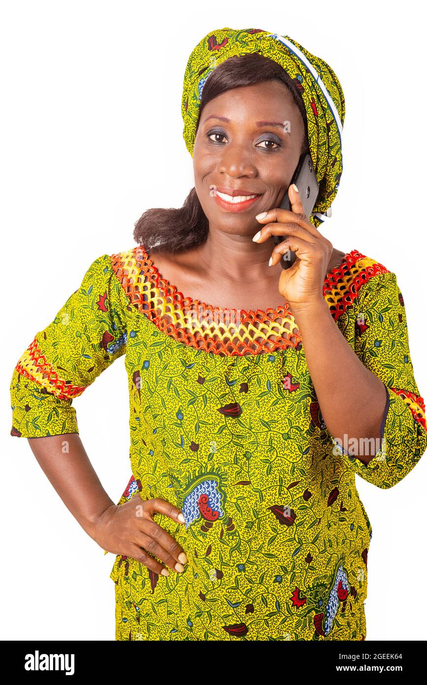 Belle femme adulte africaine portant un chiffon vert est de téléphoner suivi d'un beau sourire Banque D'Images