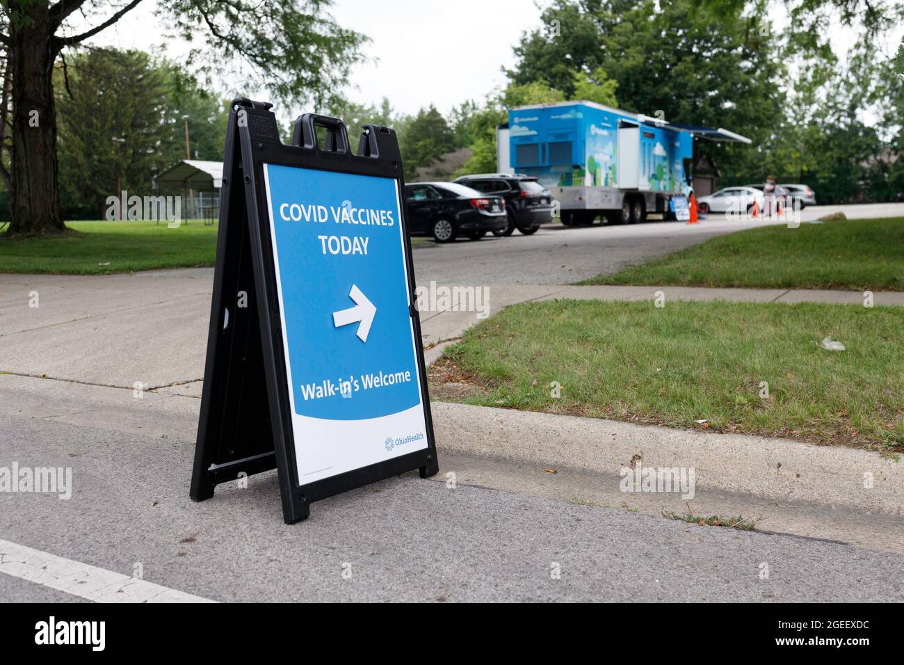 Columbus, États-Unis. 19 août 2021. Affiche indiquant à quiconque souhaite recevoir le vaccin avec la clinique garée en arrière-plan au 3840 Kimberly Parkway. La clinique mobile de vaccination Wellness on Wheels d'OhioHealth rend visite aux communautés dont le taux de vaccination est plus faible et dont l'indice de vulnérabilité sociale est élevé afin d'offrir aux personnes des vaccins gratuits contre le coronavirus Pfizer (COVID-19). Crédit : SOPA Images Limited/Alamy Live News Banque D'Images