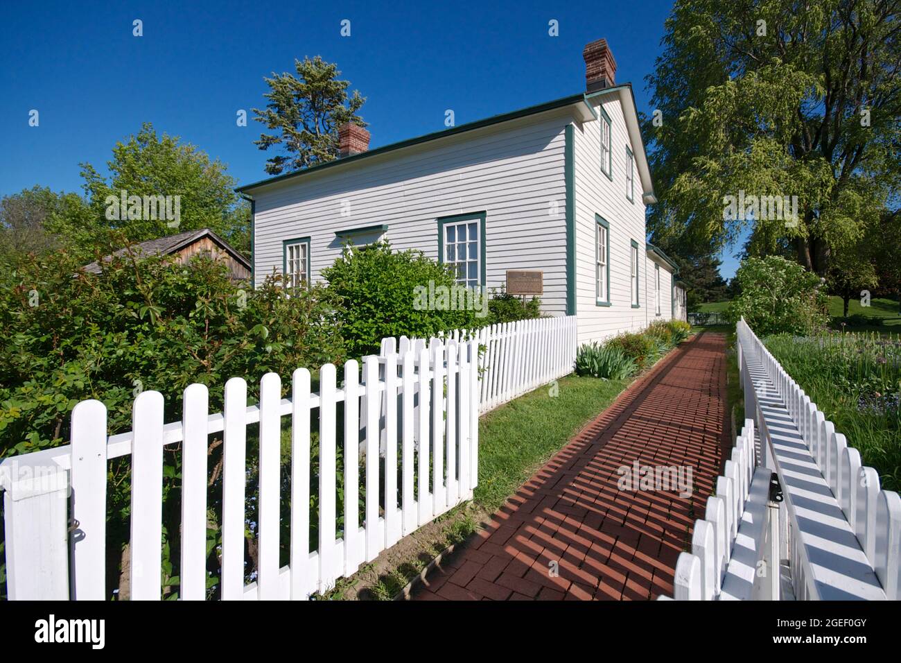 Extérieur de la maison en bois avec la clôture blanche. Banque D'Images