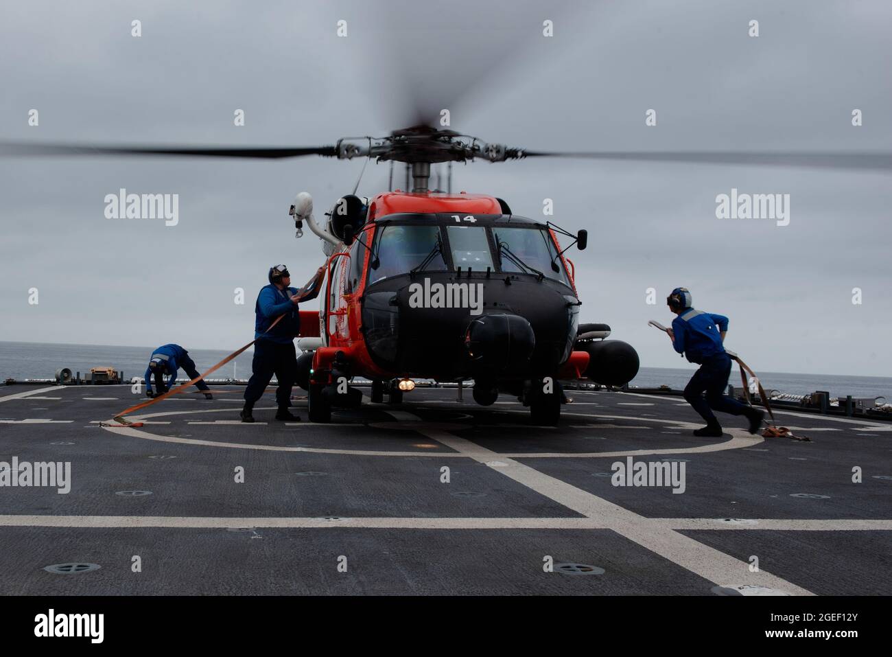 Les membres de la Garde côtière ont amené un MH-60J Jayhawk à bord du Cutter de la Garde côtière Munro dans l'océan Pacifique, le 25 juillet 2021. Le Cutter Munro de la Garde côtière va se lancer dans l'océan Pacifique occidental pour renforcer les alliances et les partenariats et améliorer la gouvernance et la sécurité maritimes dans la région. (É.-U. Photo du corps marin par Sgt. Kevin G. Rivas) Banque D'Images