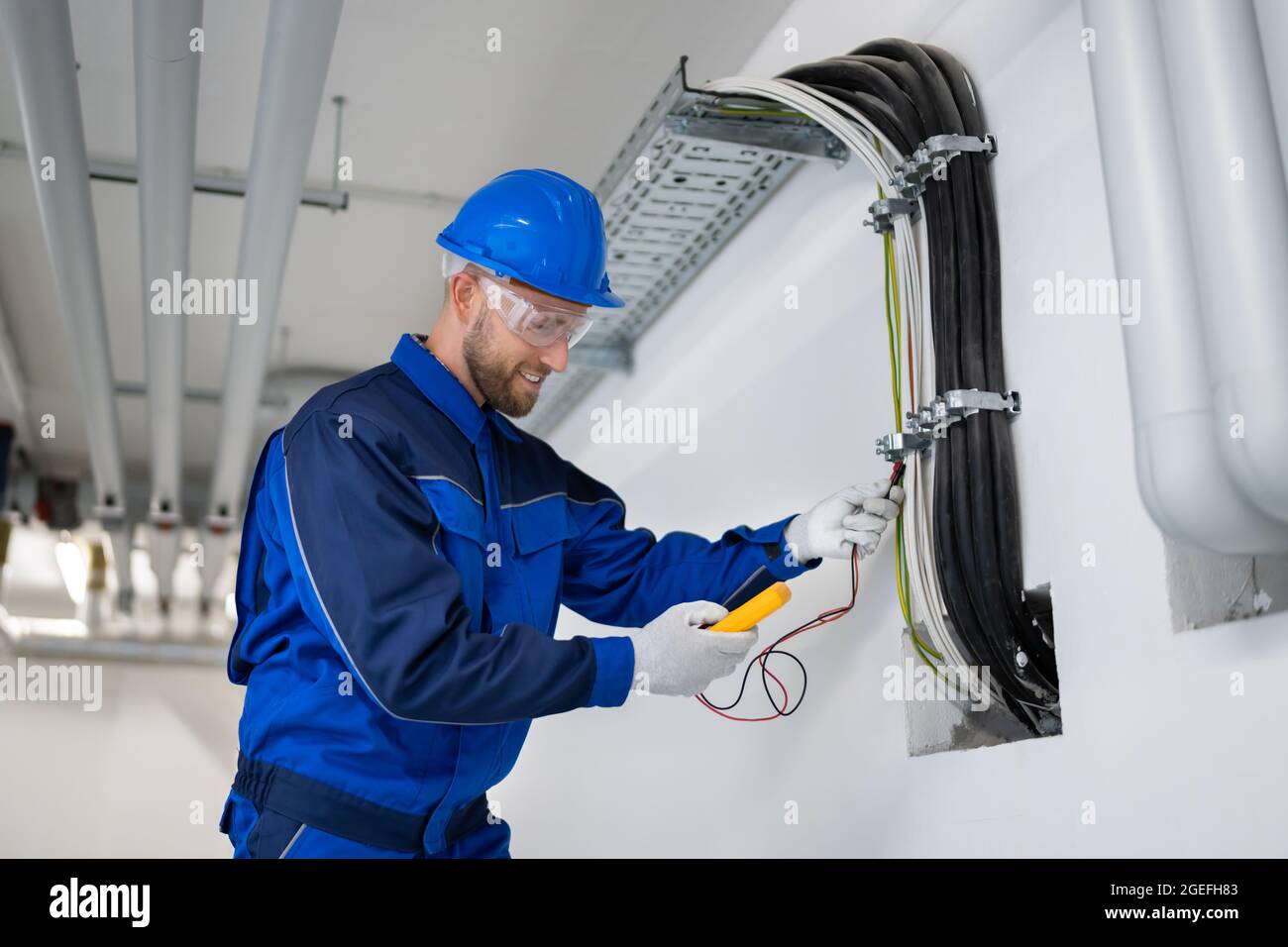 Électricien chargé de l'installation et de la maintenance des câbles au bureau Banque D'Images