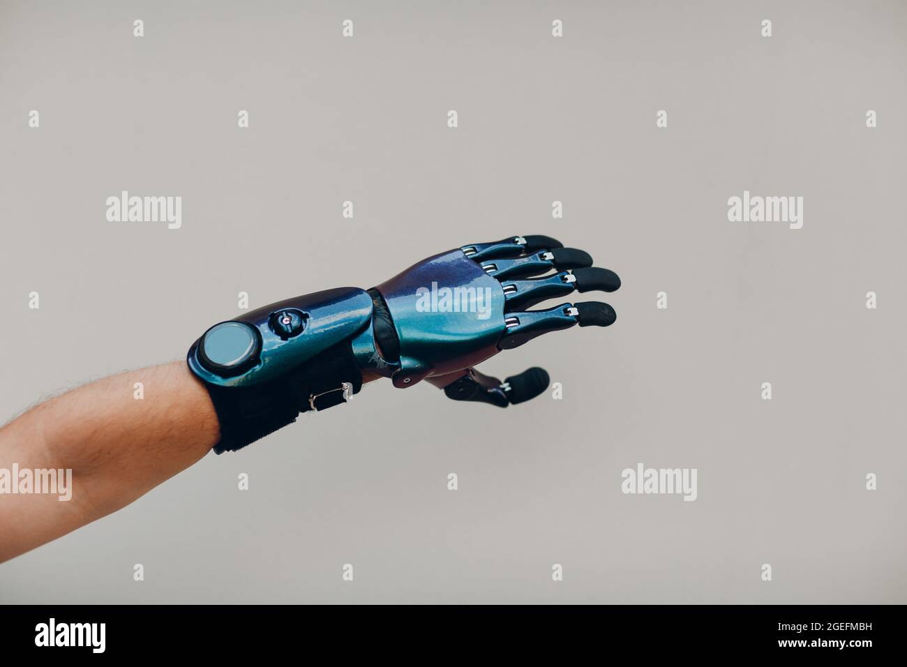 Homme handicapé avec une main prothétique artificielle gros plan de la main mâle sur fond gris Banque D'Images